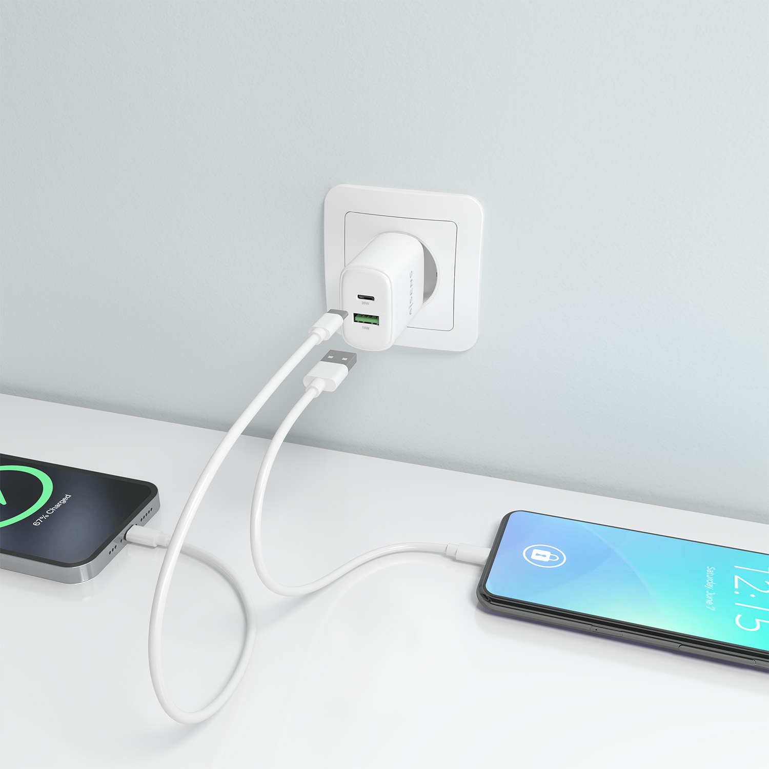 Zwei Smartphones laden. Eines bei 67 %, das andere zeigt 12:15 Uhr an. Weißes Ladegerät in der Steckdose mit zwei weißen Kabeln.