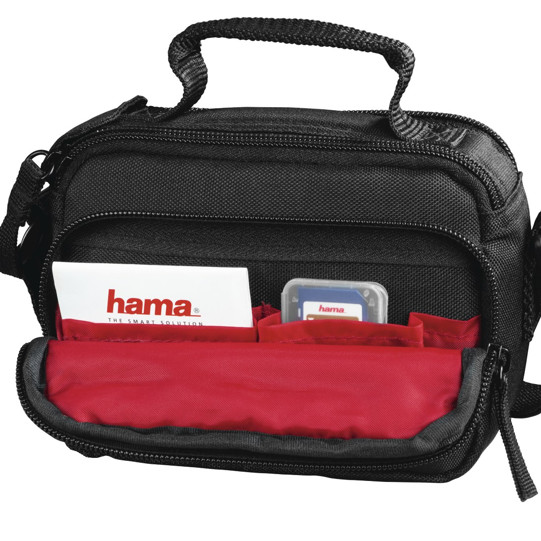 Eine schwarze Hama-Kameratasche ist geöffnet und zeigt ein rotes Innere. Eine Hama-Karte und eine Speicherkarte sind sichtbar.