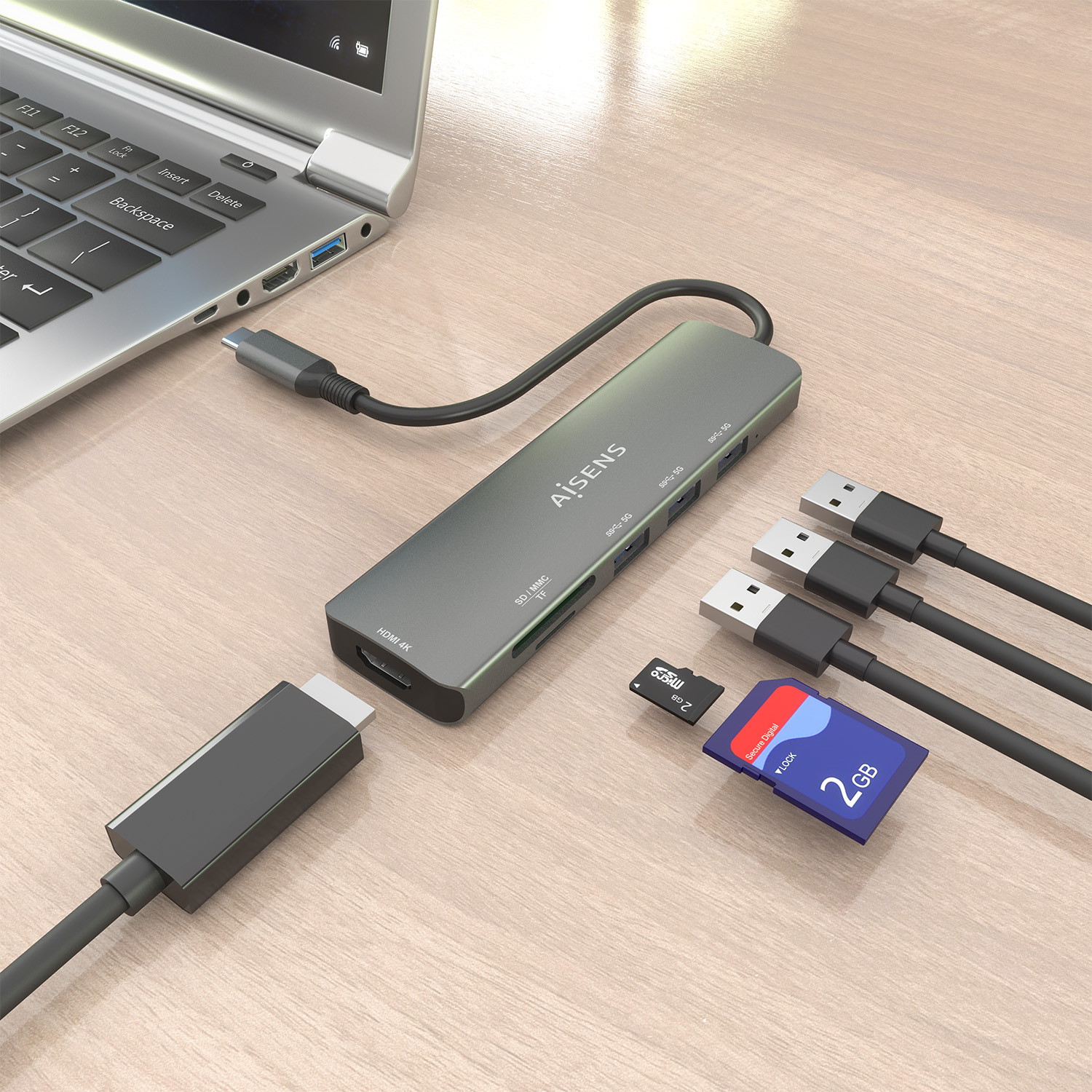 Laptop, hub, cavi USB e schede di memoria su legno. L'hub è collegato al laptop. Le schede sono da 2 GB.