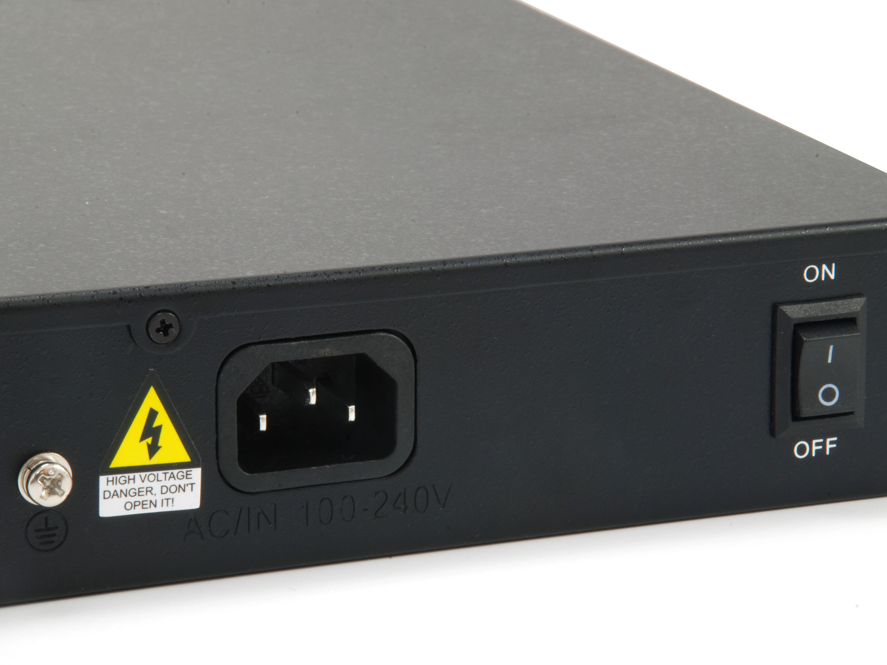 Primer plano de un dispositivo electrónico negro. Tiene una entrada de alimentación, un interruptor de encendido y una etiqueta de advertencia.