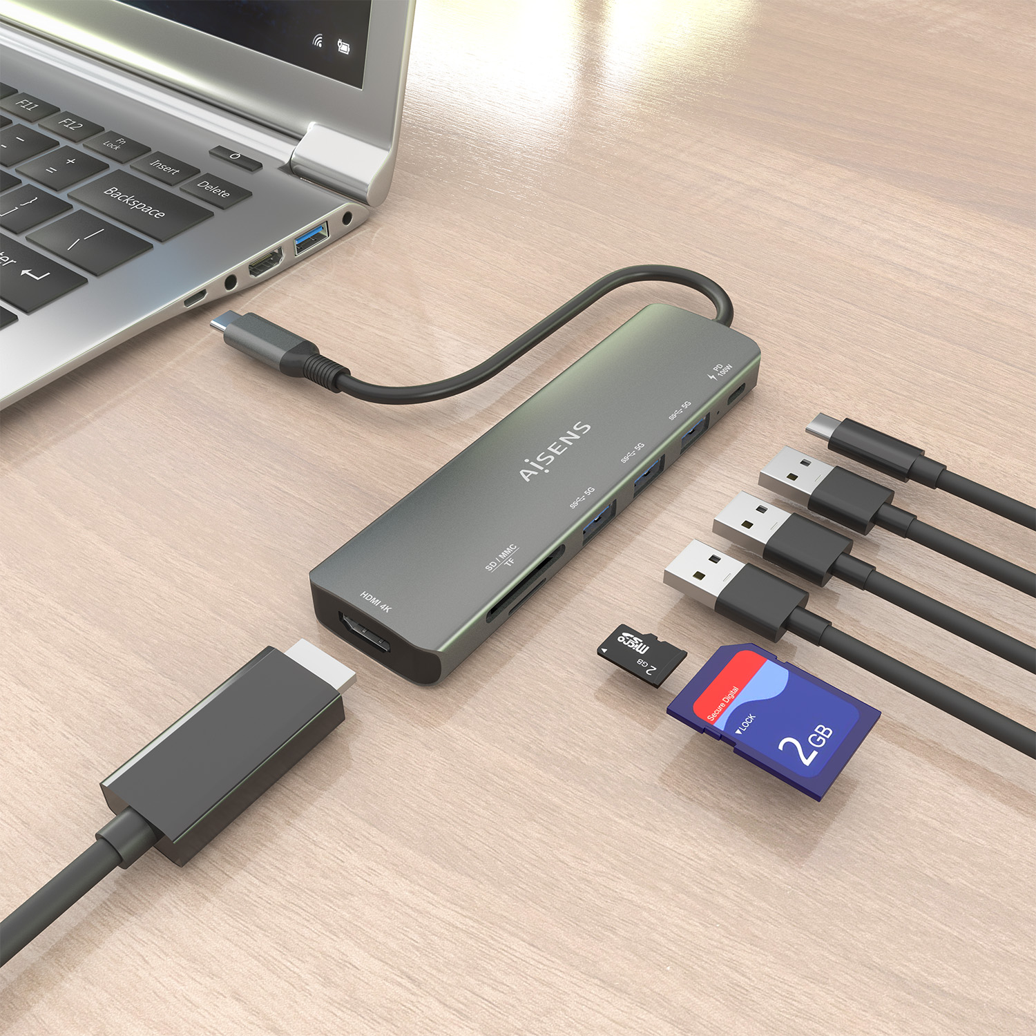 Un laptop con un hub USB, cavi USB e schede SD su un tavolo di legno. L'hub è collegato al laptop.