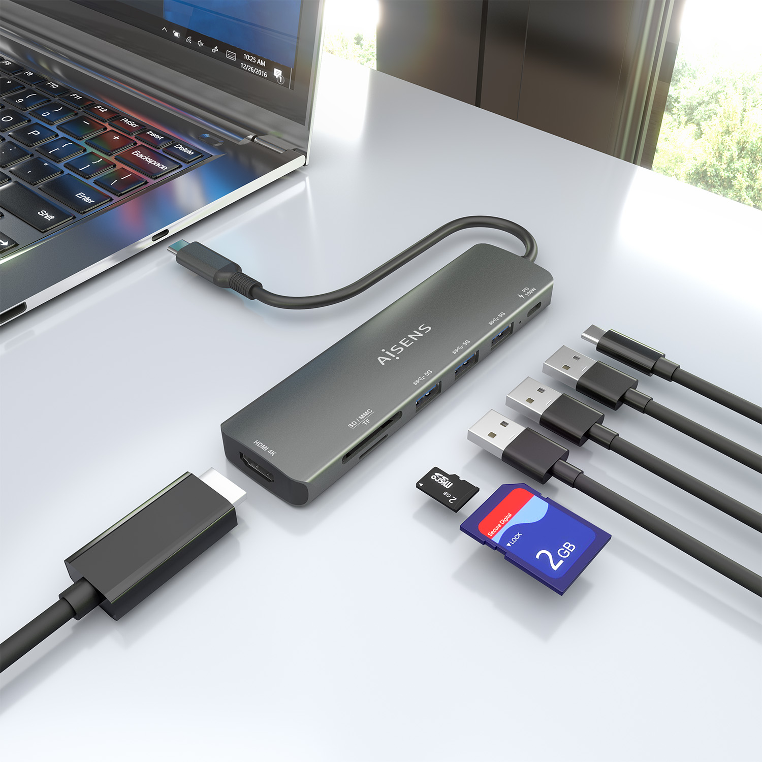 Un laptop, un hub USB-C e diversi cavi sono su una scrivania bianca. Sono presenti anche schede SD e un laptop.