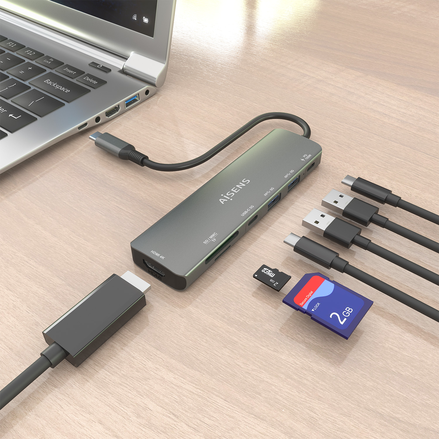 Un laptop con hub USB-C, cavi collegati, schede SD e unità USB su una superficie di legno.