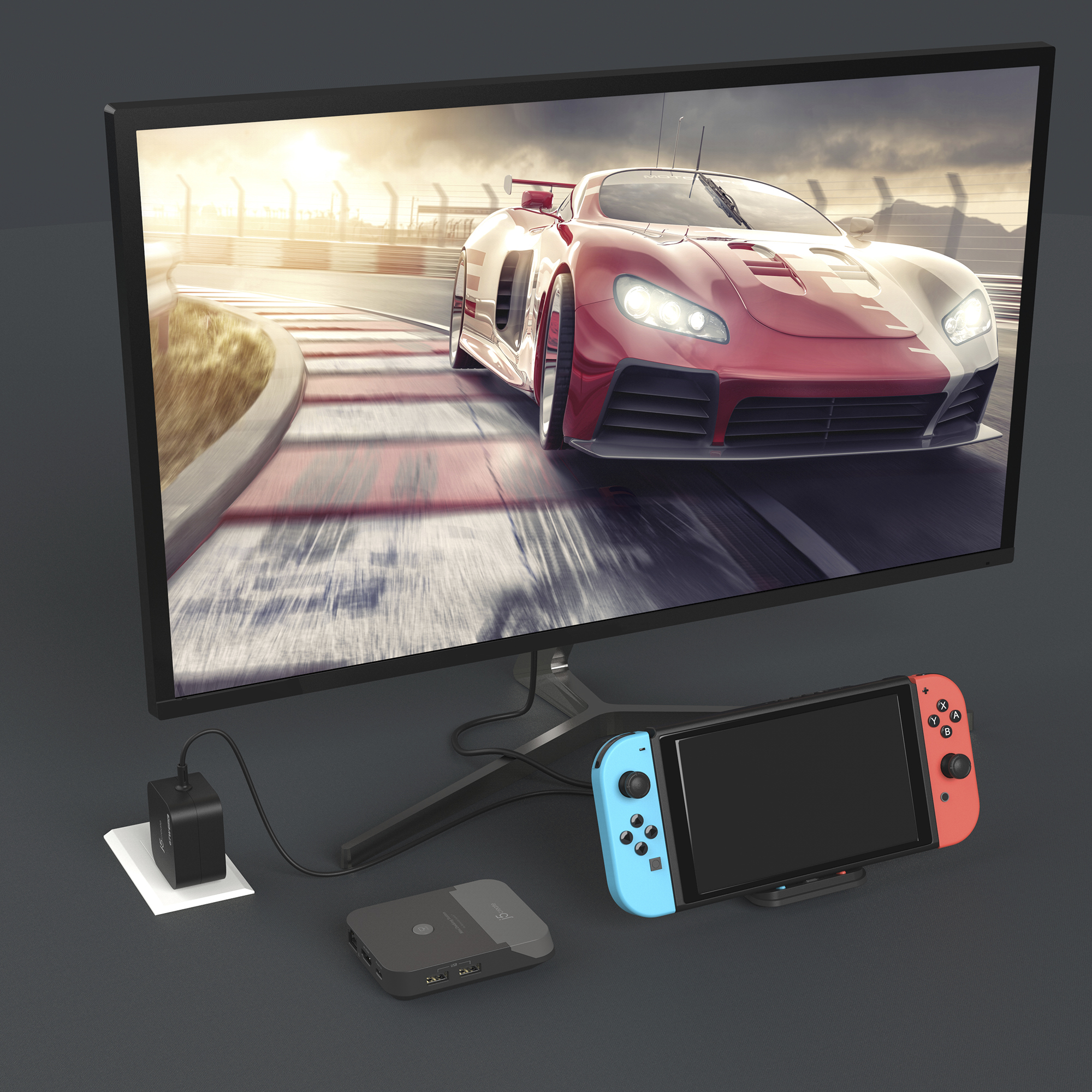 Ein Monitor zeigt ein rotes Rennauto auf einer Rennstrecke. Eine Switch-Konsole und Zubehör befinden sich im Vordergrund.
