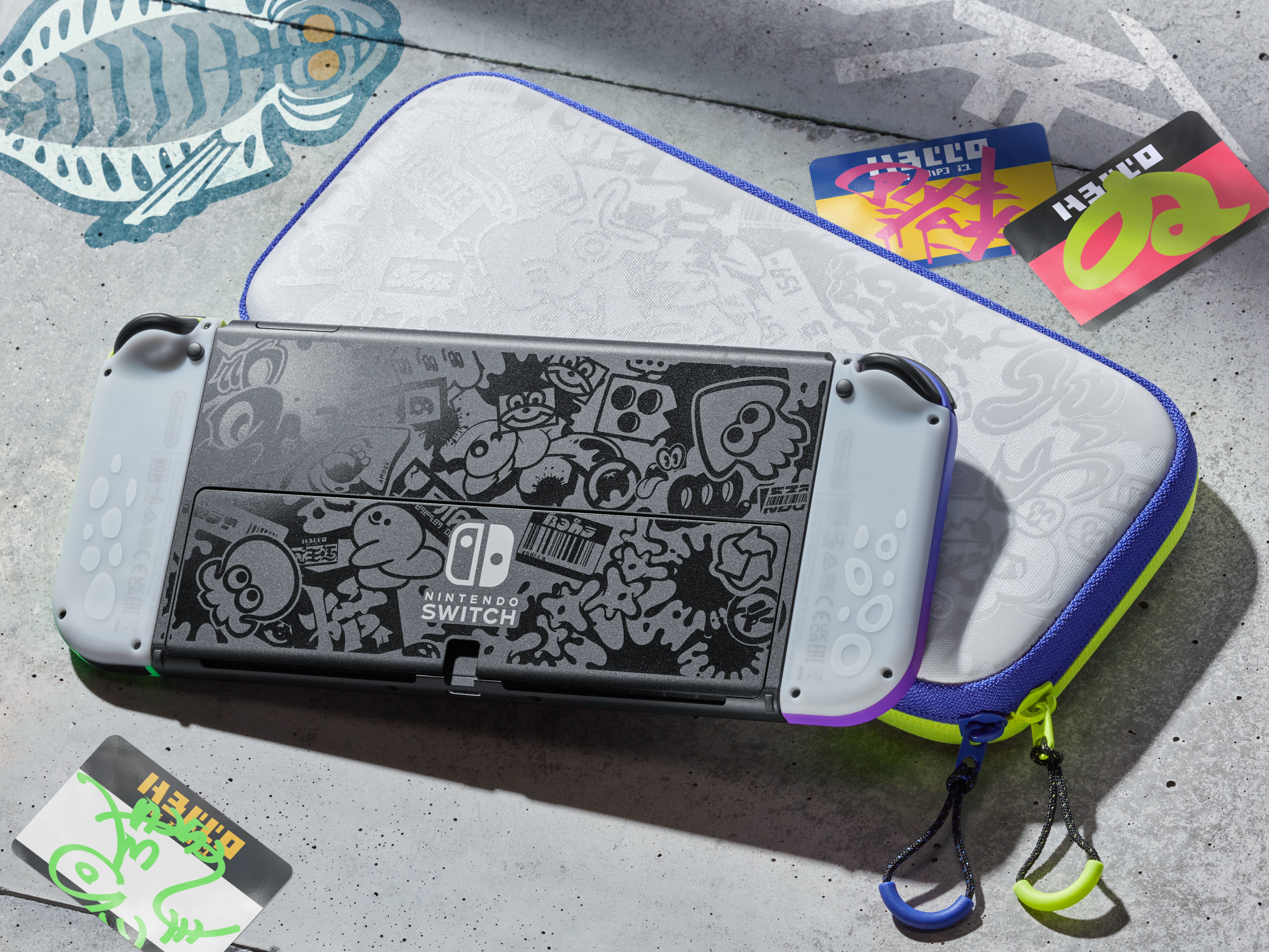 Consola Nintendo Switch con funda y tarjetas de juego sobre una superficie texturizada. La consola tiene arte único.