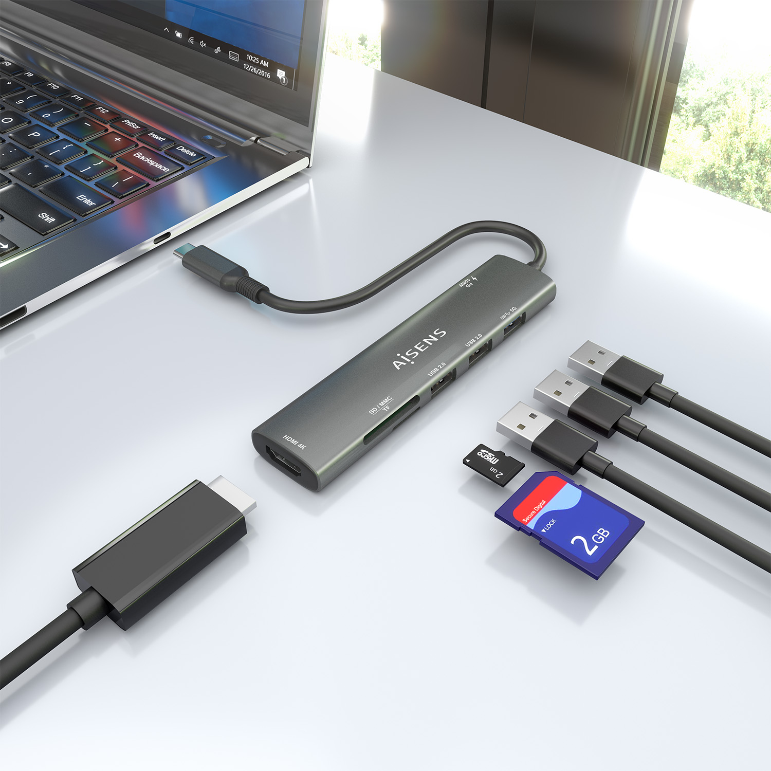 Ein Laptop mit USB-Hub, SD-Karten und USB-Kabeln auf einer weißen Oberfläche. Der Hub ist mit dem Laptop verbunden. Die Szene ist hell.