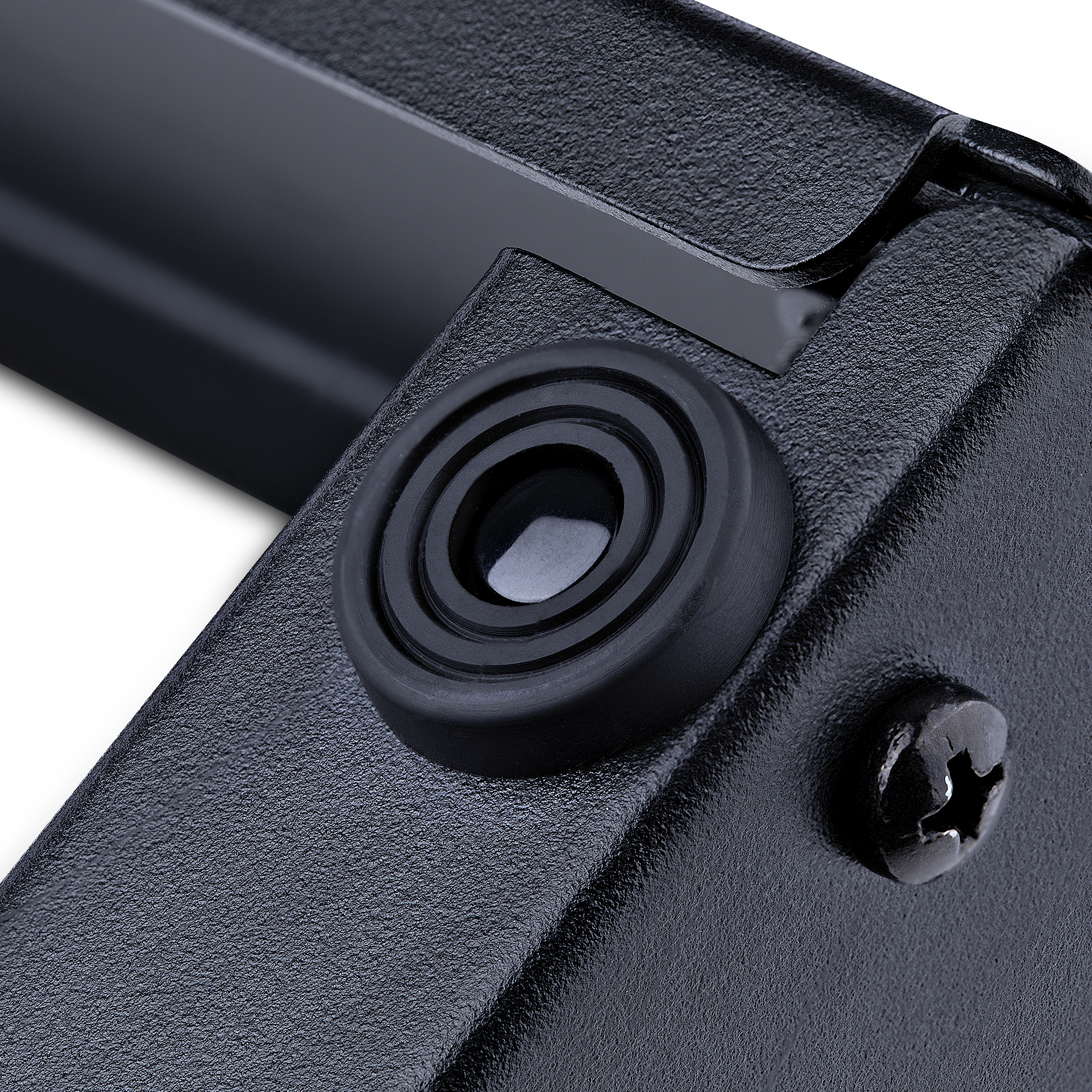 Primer plano de un objeto metálico negro. Se ven una pieza de goma circular, un tornillo y superficies texturizadas.