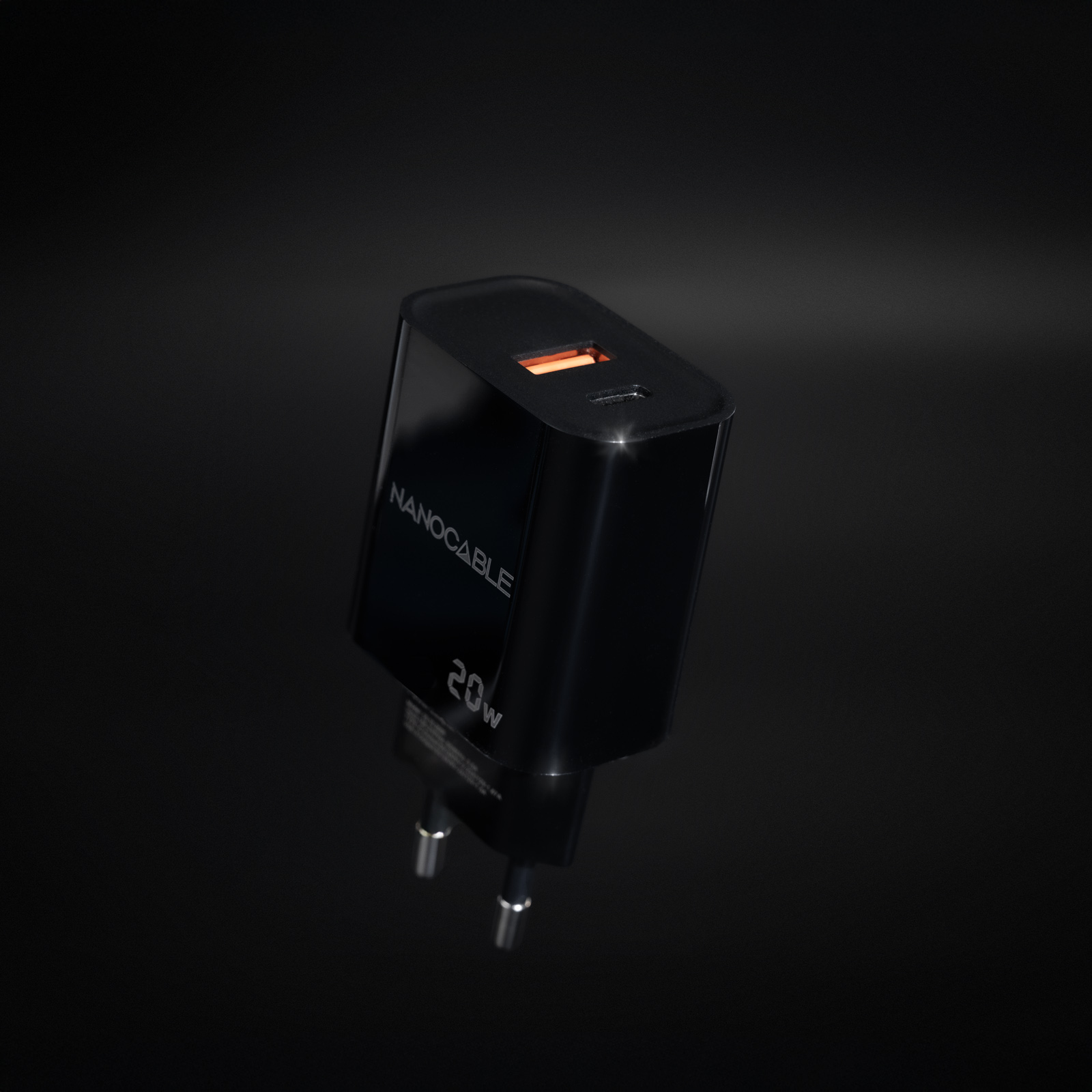 Ein schwarzes Nanocable 20W Ladegerät mit USB-C-Anschluss. Der Hintergrund ist ein Gradient von Dunkelgrau zu Schwarz.