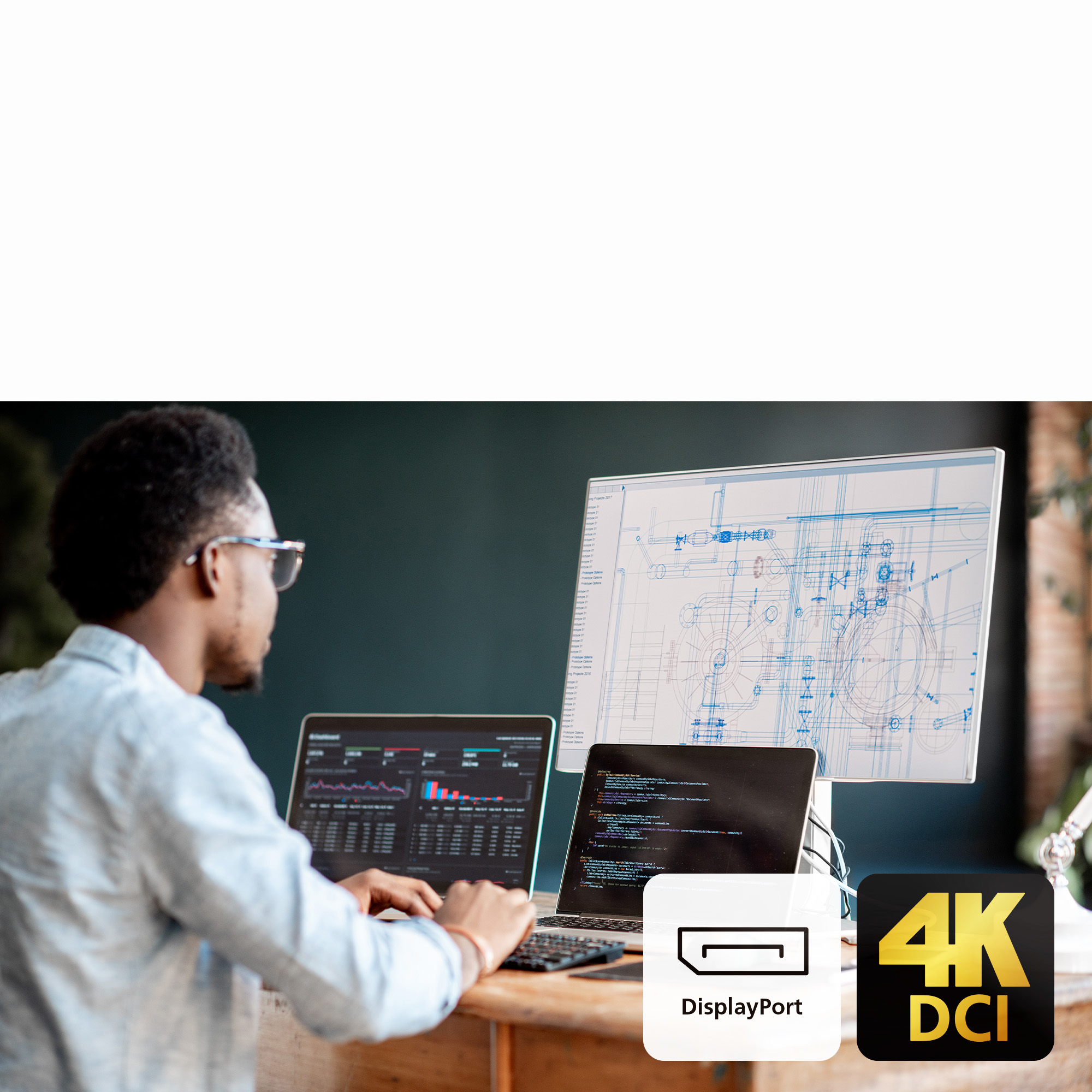 Un homme travaille sur des ordinateurs portables, l'un affiche des graphiques, l'autre du code. Grand écran affiche des plans. Logos DisplayPort et 4K DCI.