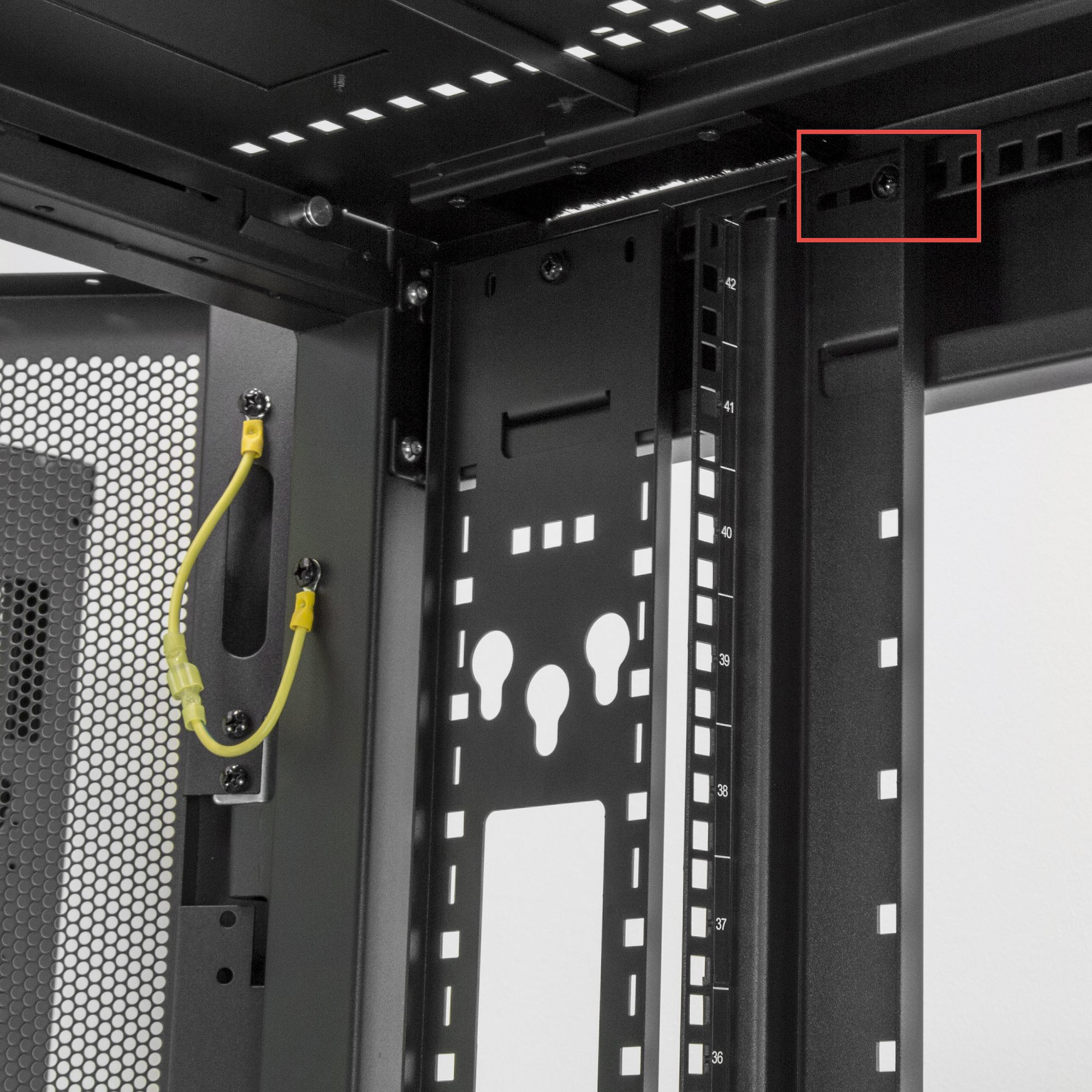 Innenansicht eines schwarzen Serverracks. Enthält ein gelbes Kabel, Lochblech und nummerierte Schienen für Geräte.