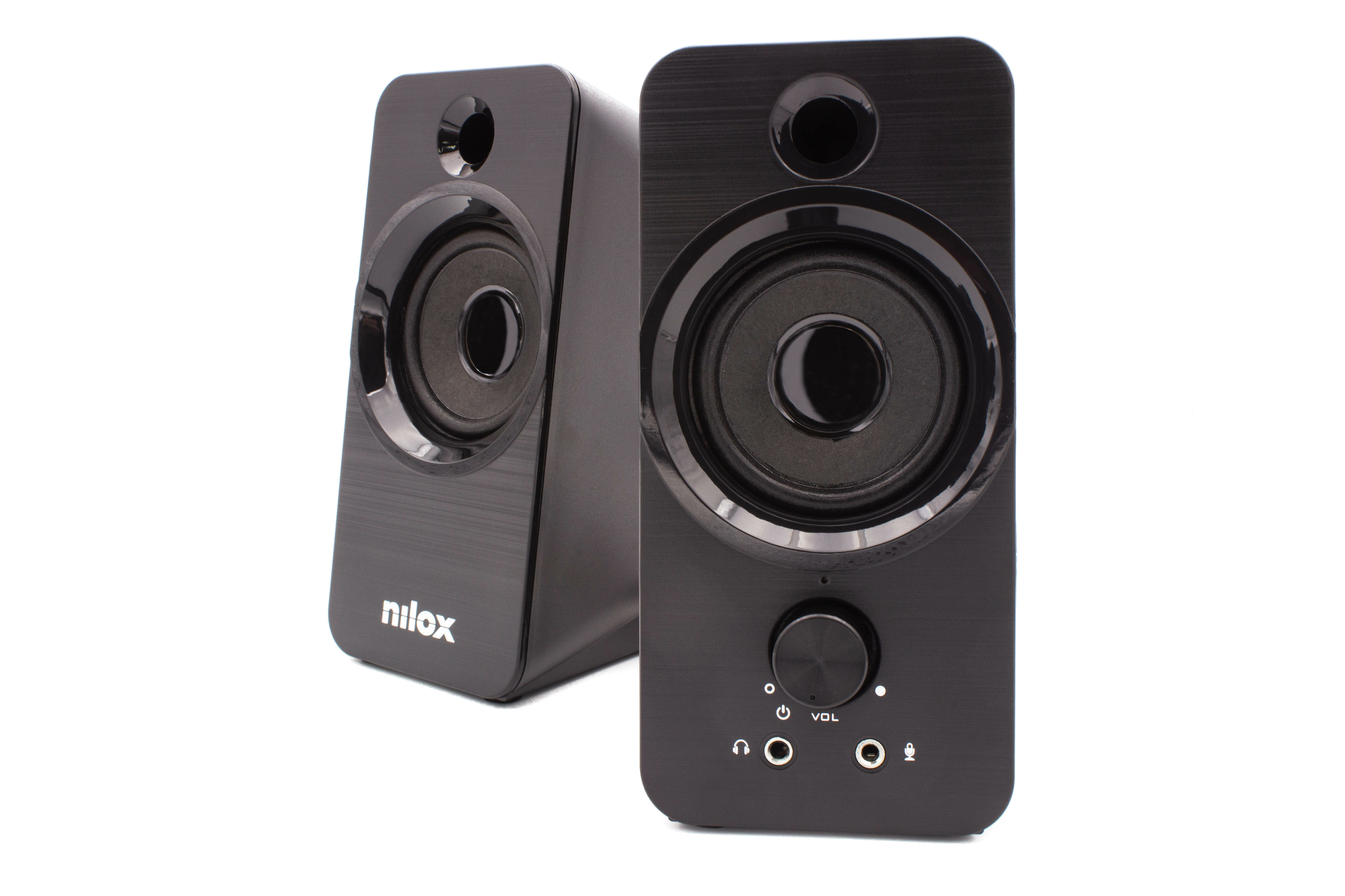 Dos altavoces negros para computadora sobre fondo blanco. Uno está más cerca con control de volumen.