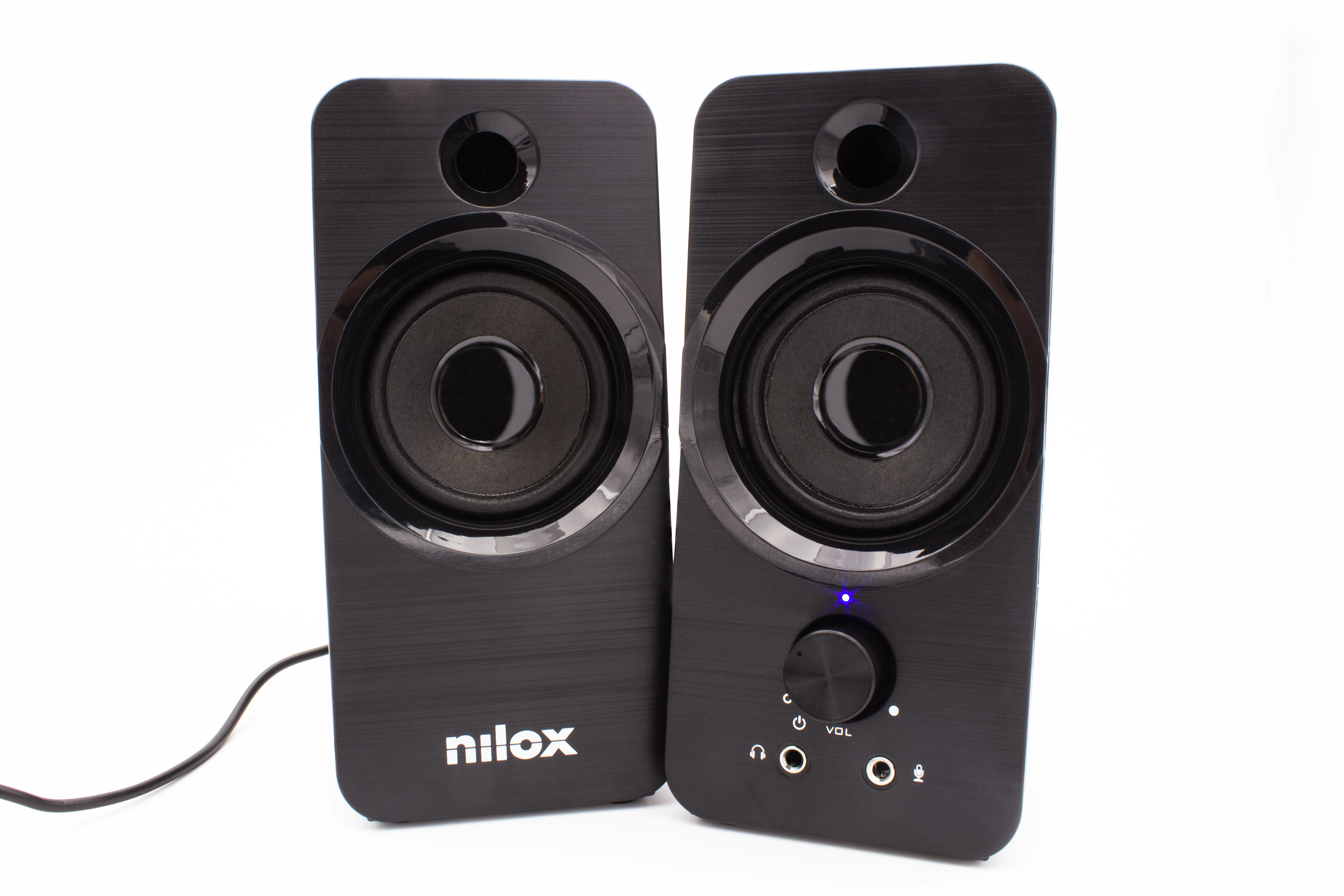 Dos altavoces de ordenador negros sobre fondo blanco. Uno tiene control de volumen y una luz azul.