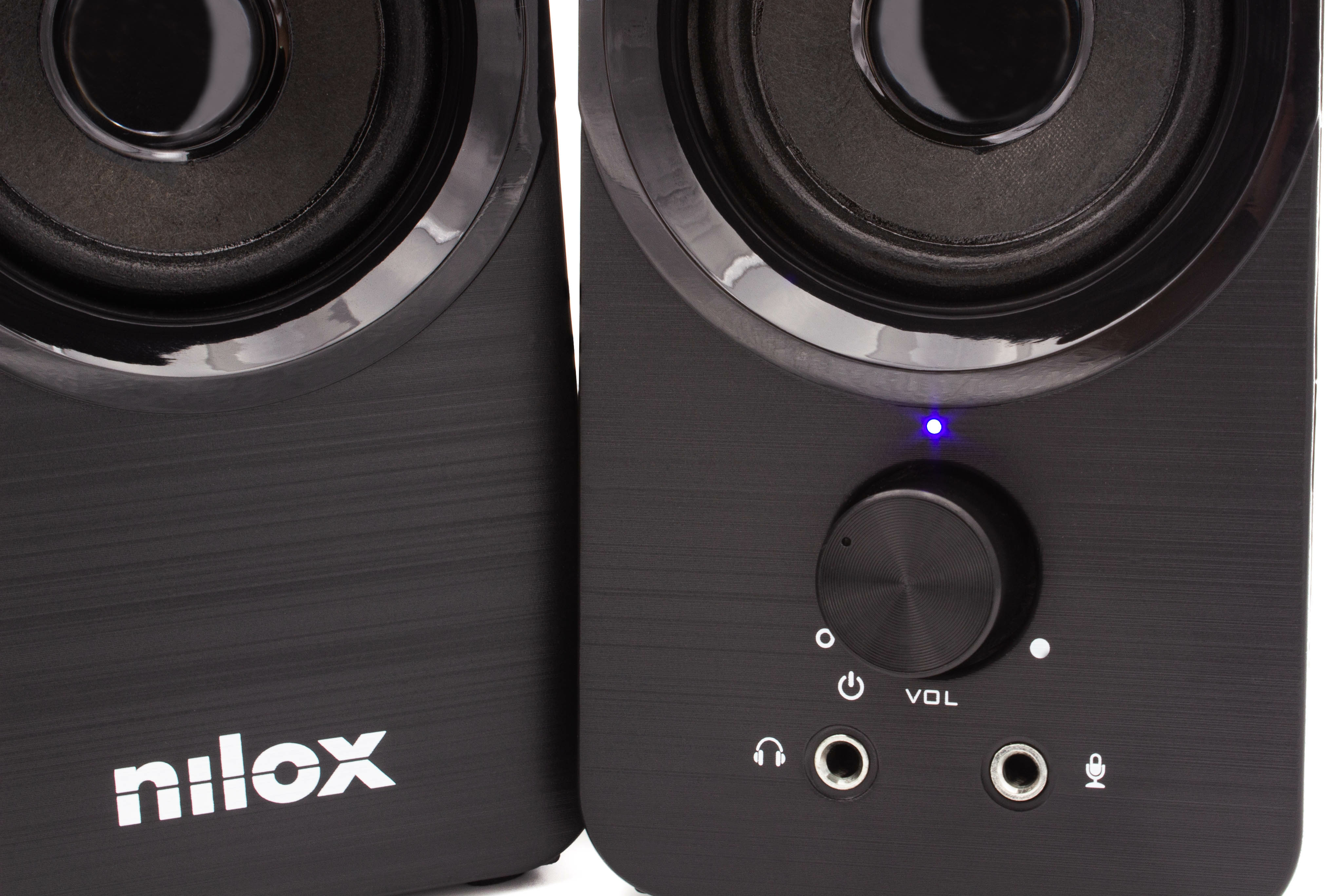 Dos altavoces negros, uno con el logotipo 'nilox'. El altavoz derecho tiene un mando de volumen y luces indicadoras.