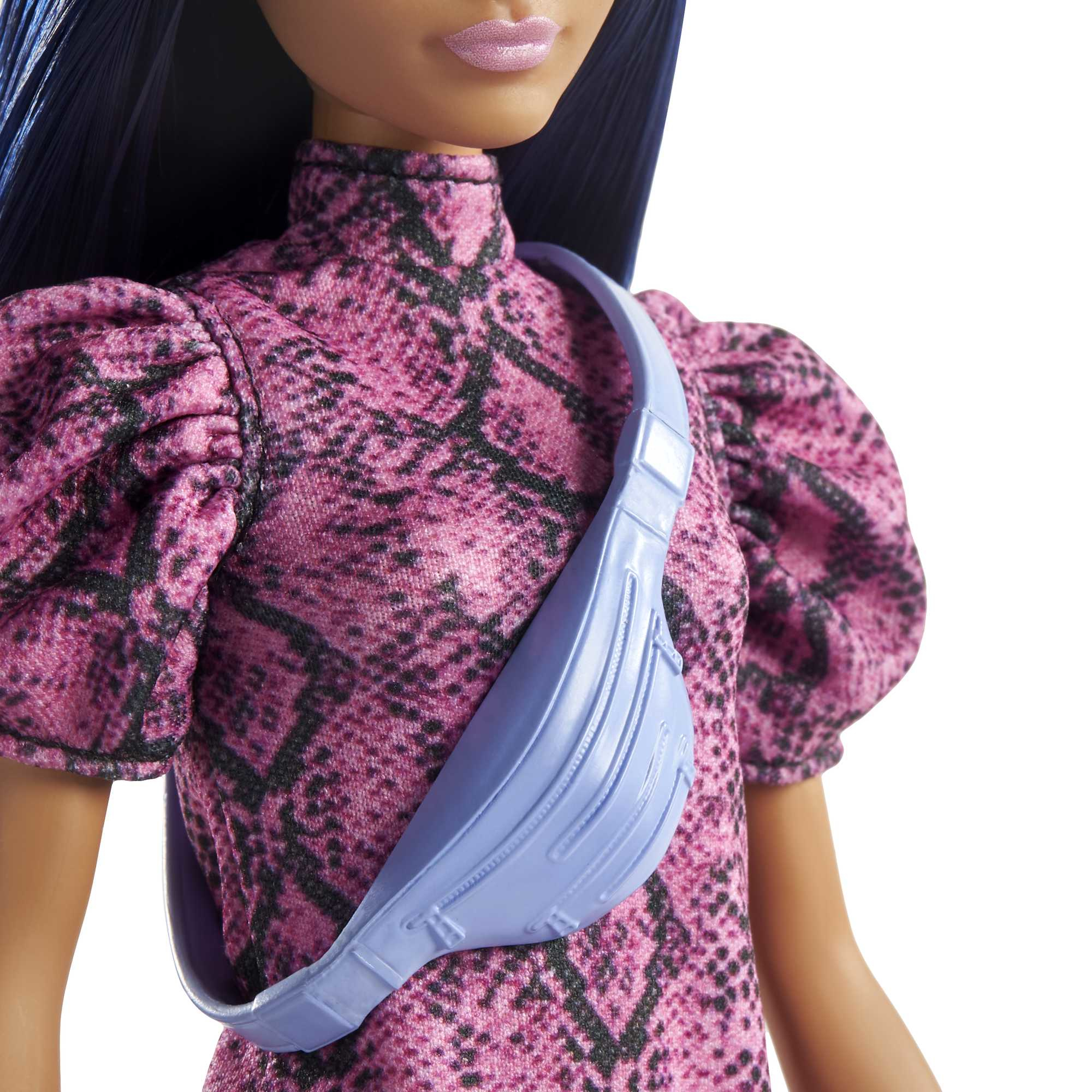 Nahaufnahme einer Puppe mit blauen Haaren, die ein rosa Kleid mit Schlangenmuster und eine blaue Tasche trägt.
