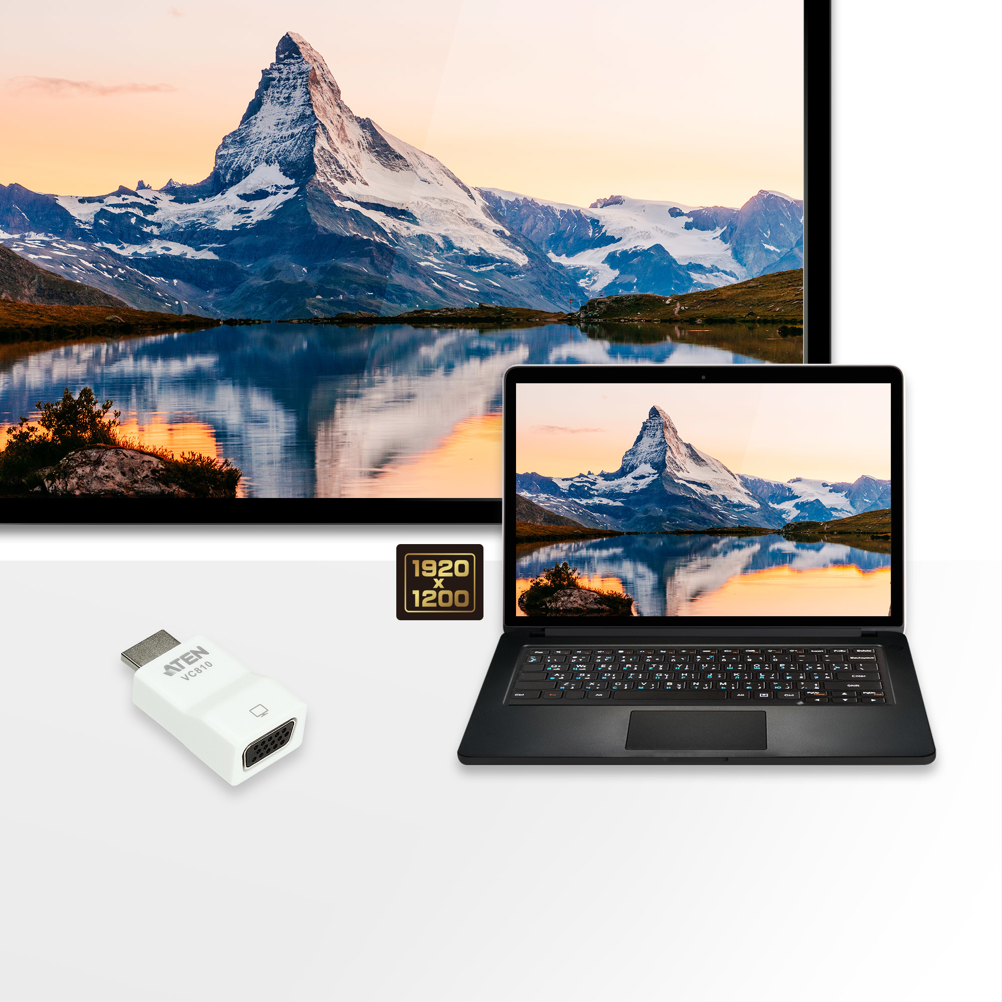 Laptop und Fernseher zeigen eine Berglandschaft. Ein weißer Adapter befindet sich im Vordergrund.
