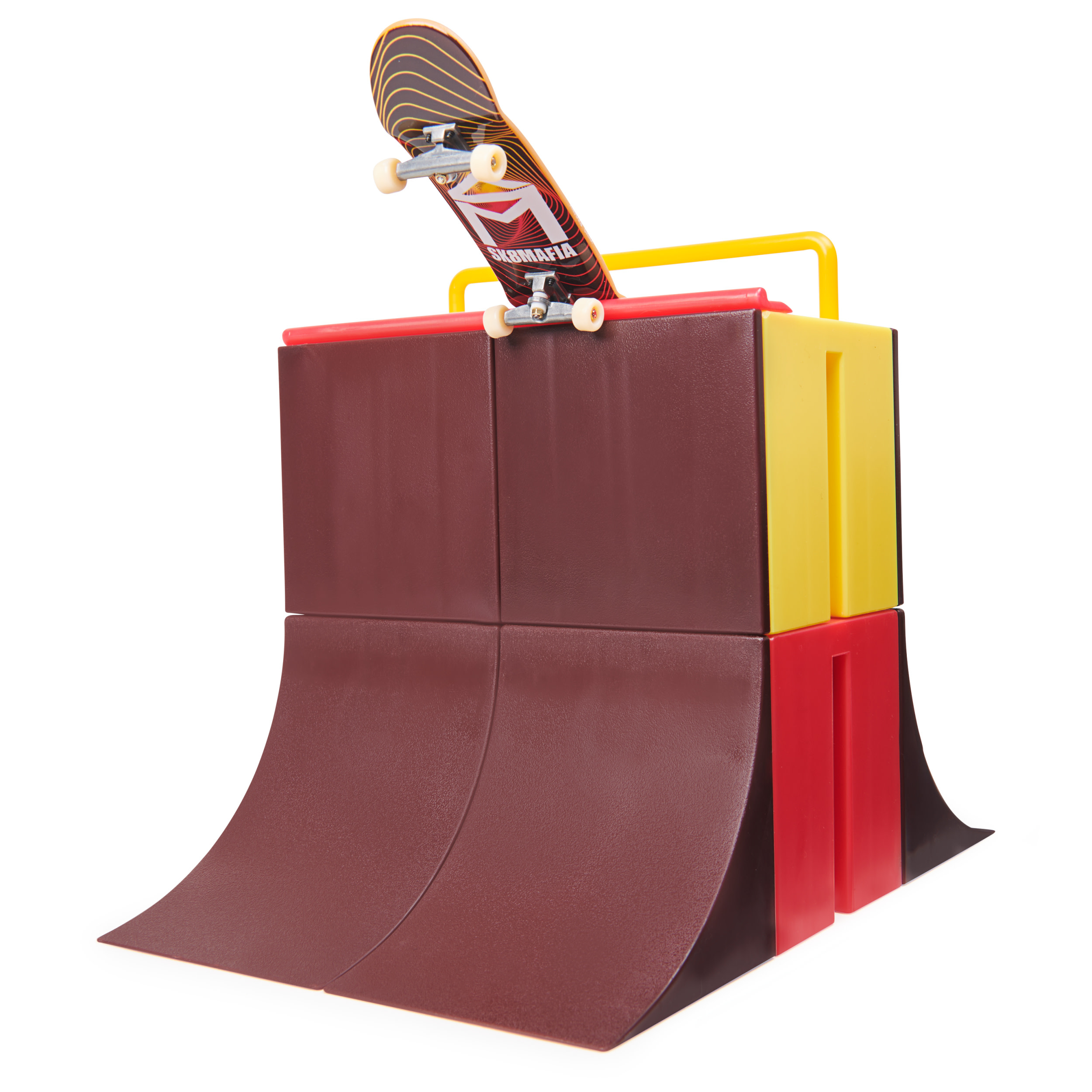 Un monopatín en una rampa de skatepark. La rampa es marrón, roja y amarilla. El monopatín tiene un diseño negro y rojo.