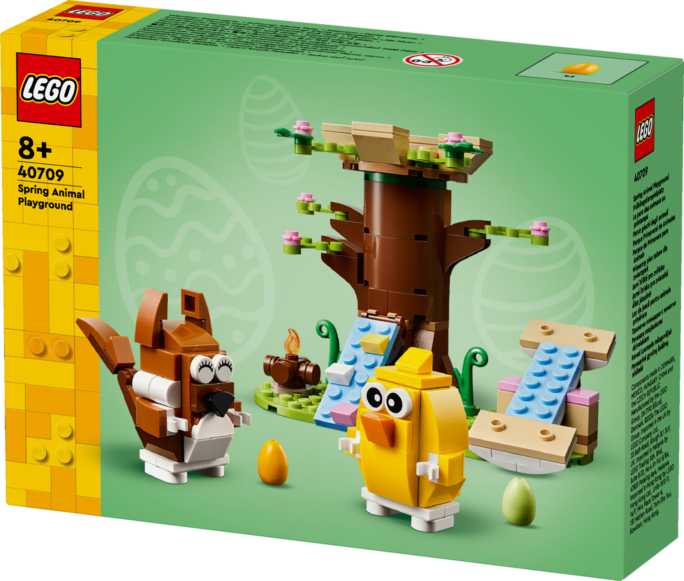 Scatola Lego. Presenta scoiattolo, pulcino, albero e scivoli. Sfondo verde con forme di uova.