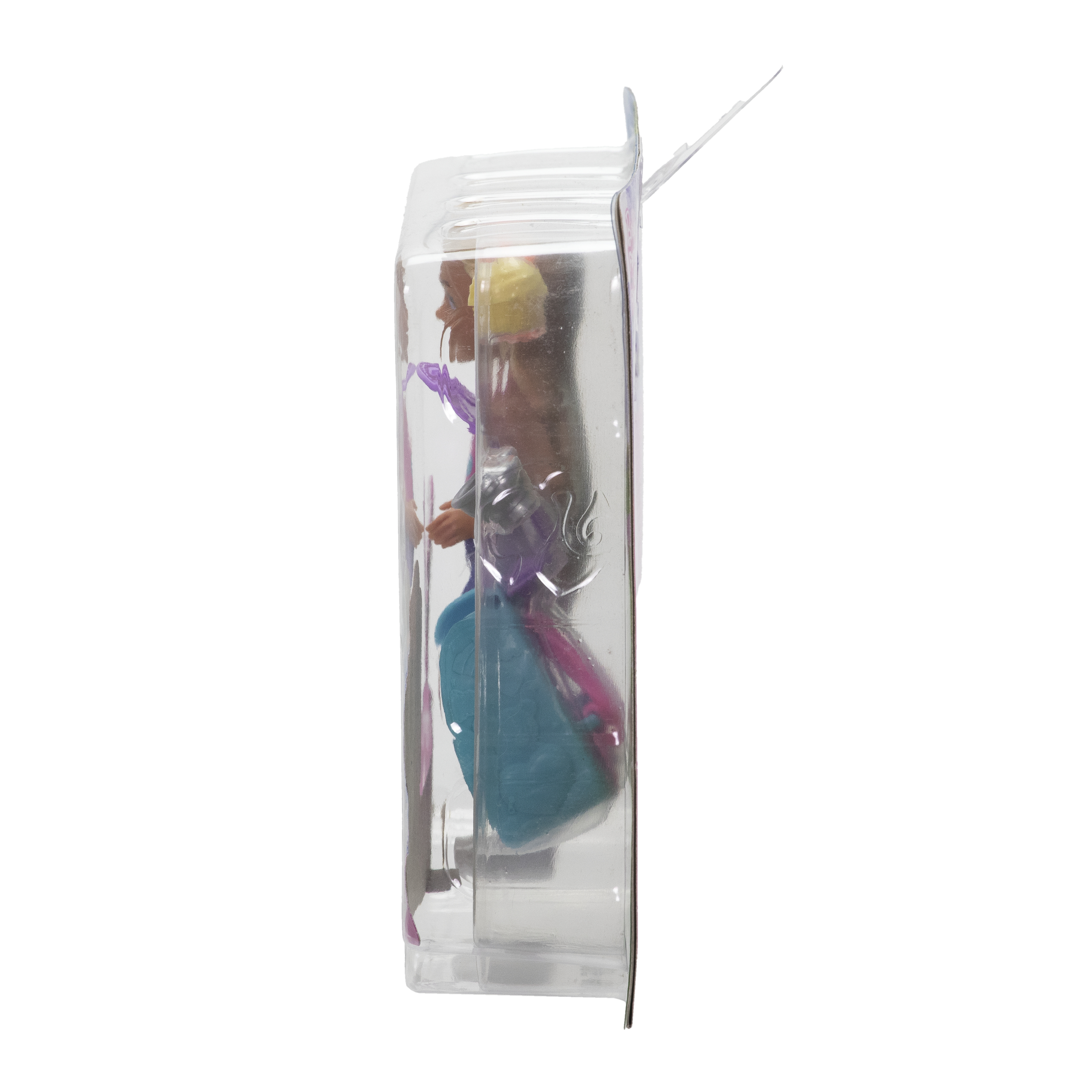 Eine Puppe in einer durchsichtigen Plastikverpackung. Die Puppe trägt ein blaues Kleid und hat blondes Haar.