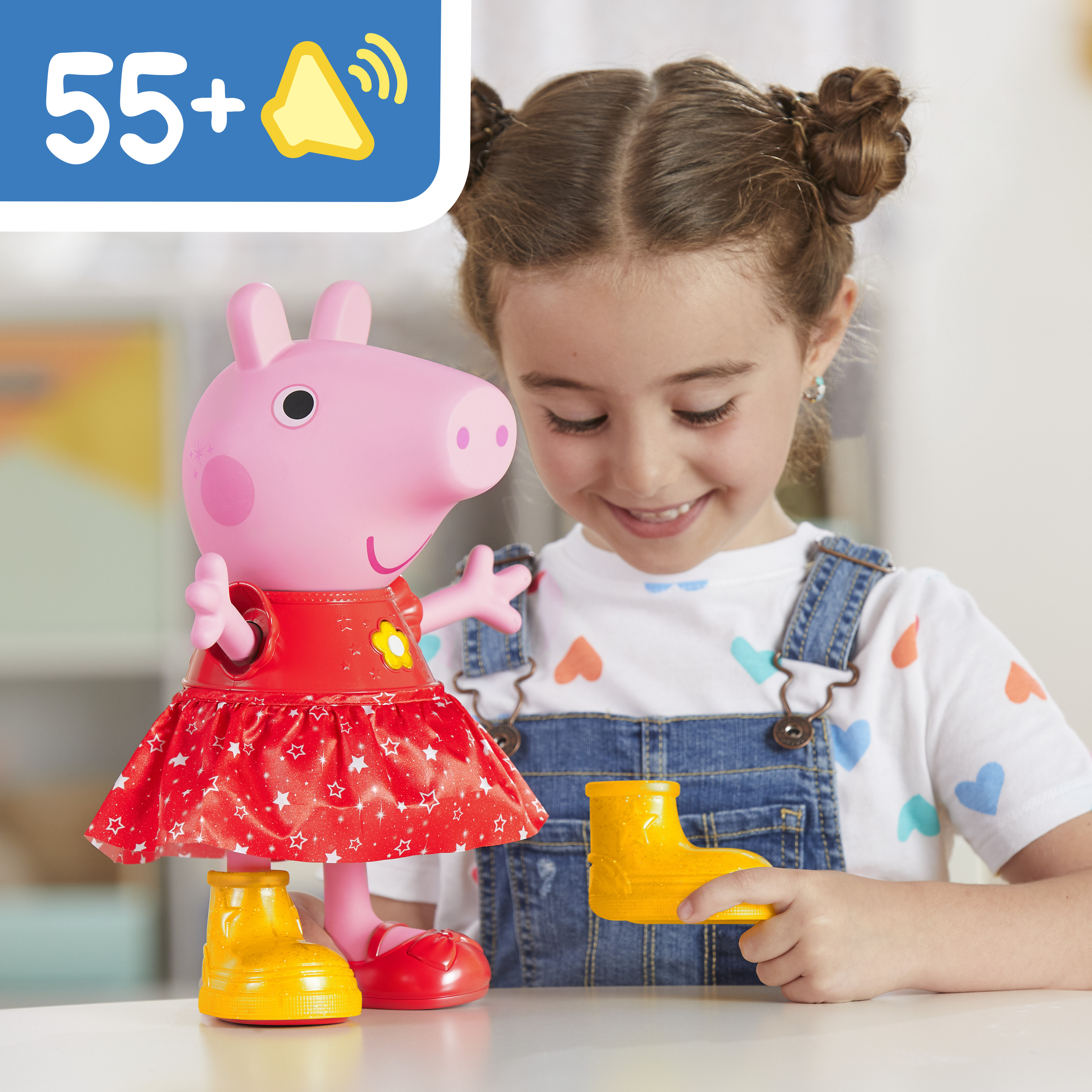 Una niña juega con un juguete de Peppa Pig, sosteniendo una bota amarilla. Peppa usa un vestido rojo y zapatos amarillos.