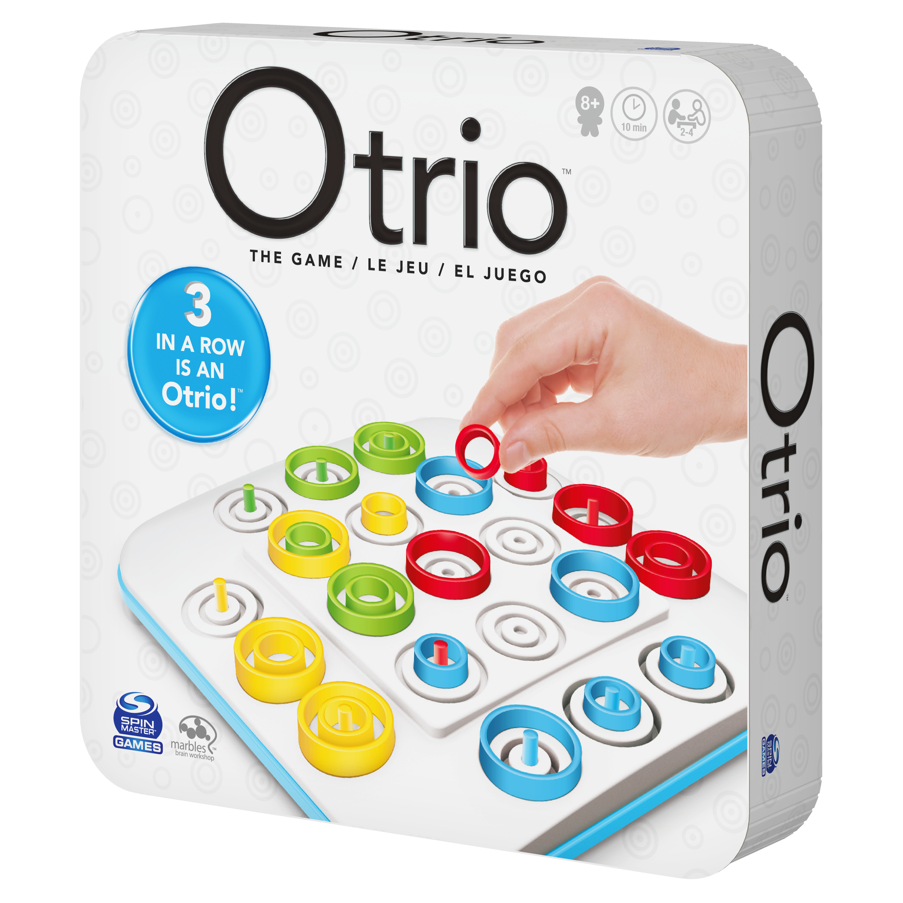 Otrio-Spielbox. Hand, die einen roten Ring auf ein Spielbrett mit farbigen Ringen legt. Auf der Box steht '3 in einer Reihe ist ein Otrio!'