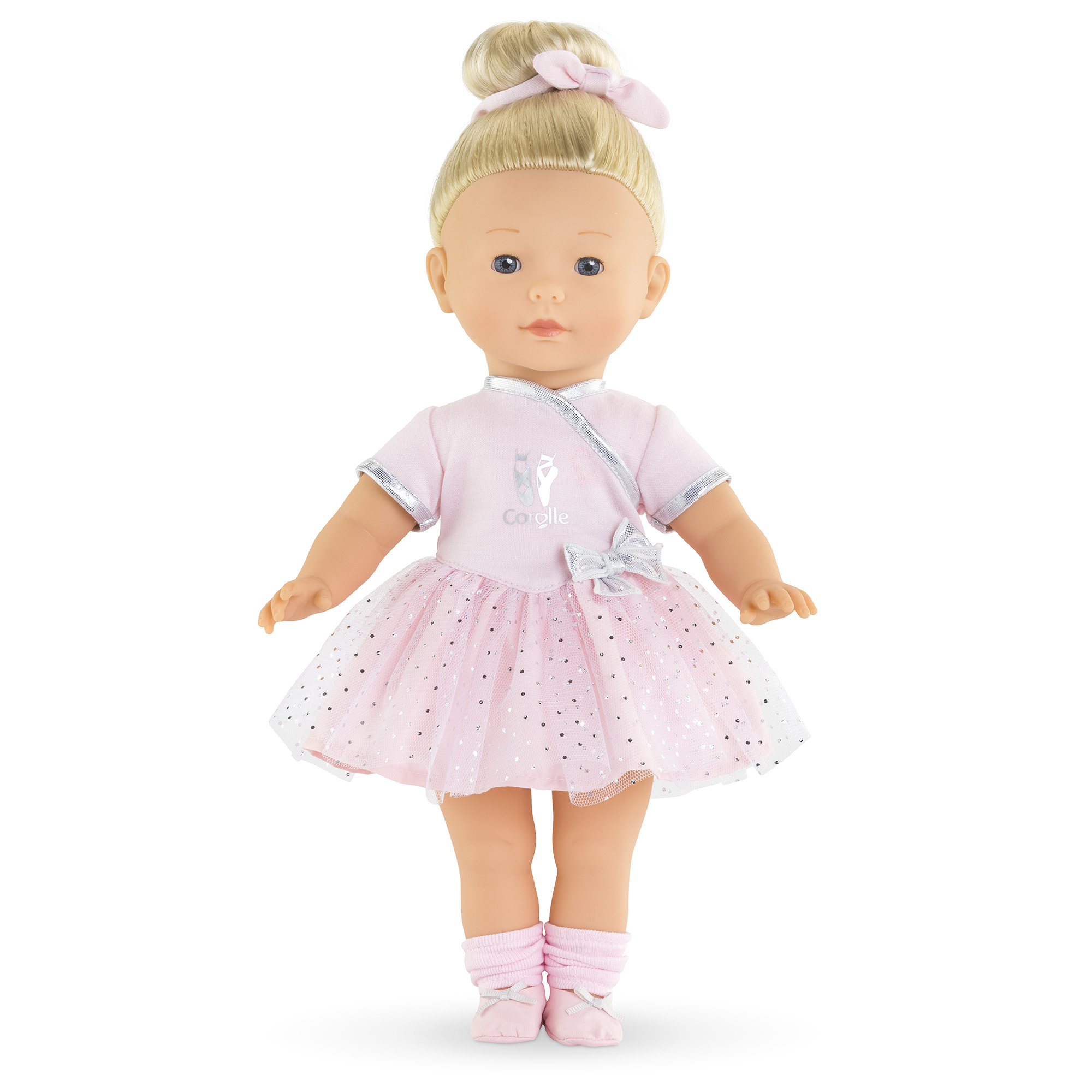 Eine Puppe in einem rosa Ballerina-Outfit steht vor weißem Hintergrund. Sie hat blonde Haare in einem Dutt mit einer rosa Schleife.