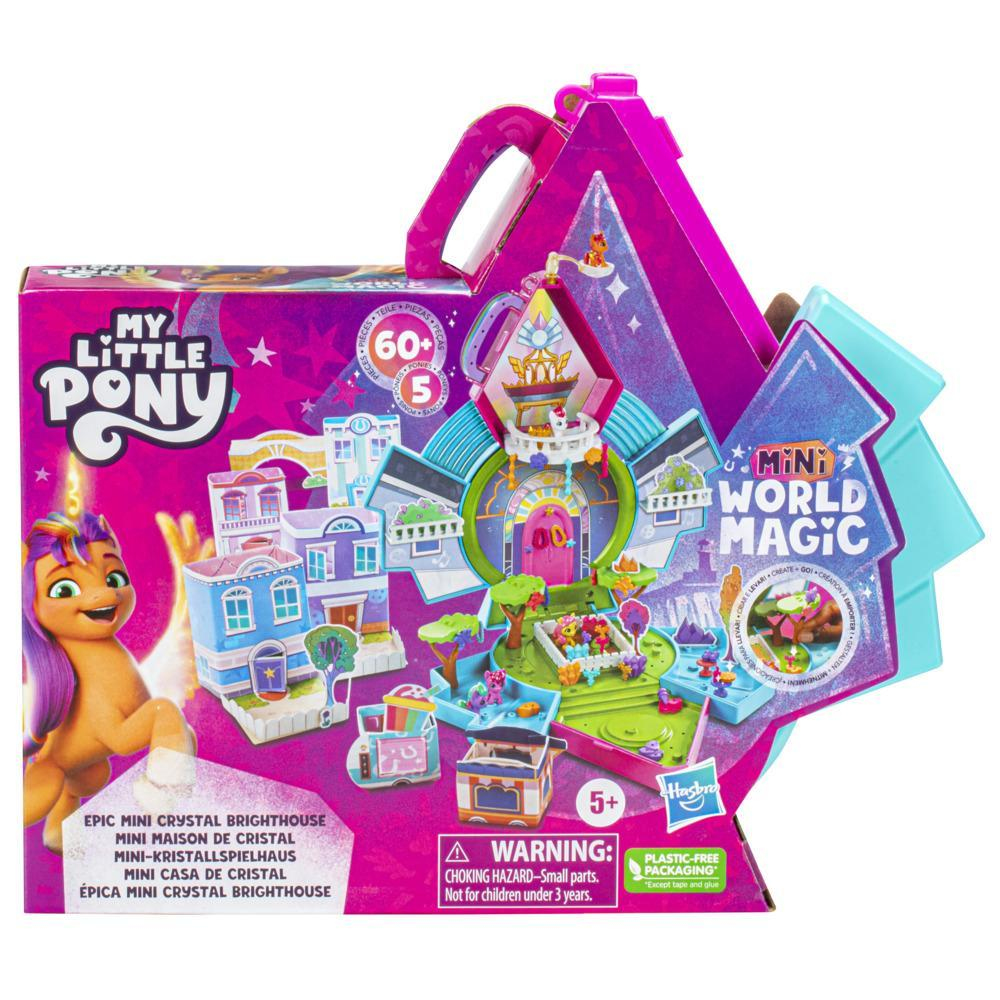 Una caja de juego de My Little Pony, abierta para revelar un mundo en miniatura con edificios, ponis y una etiqueta de advertencia.