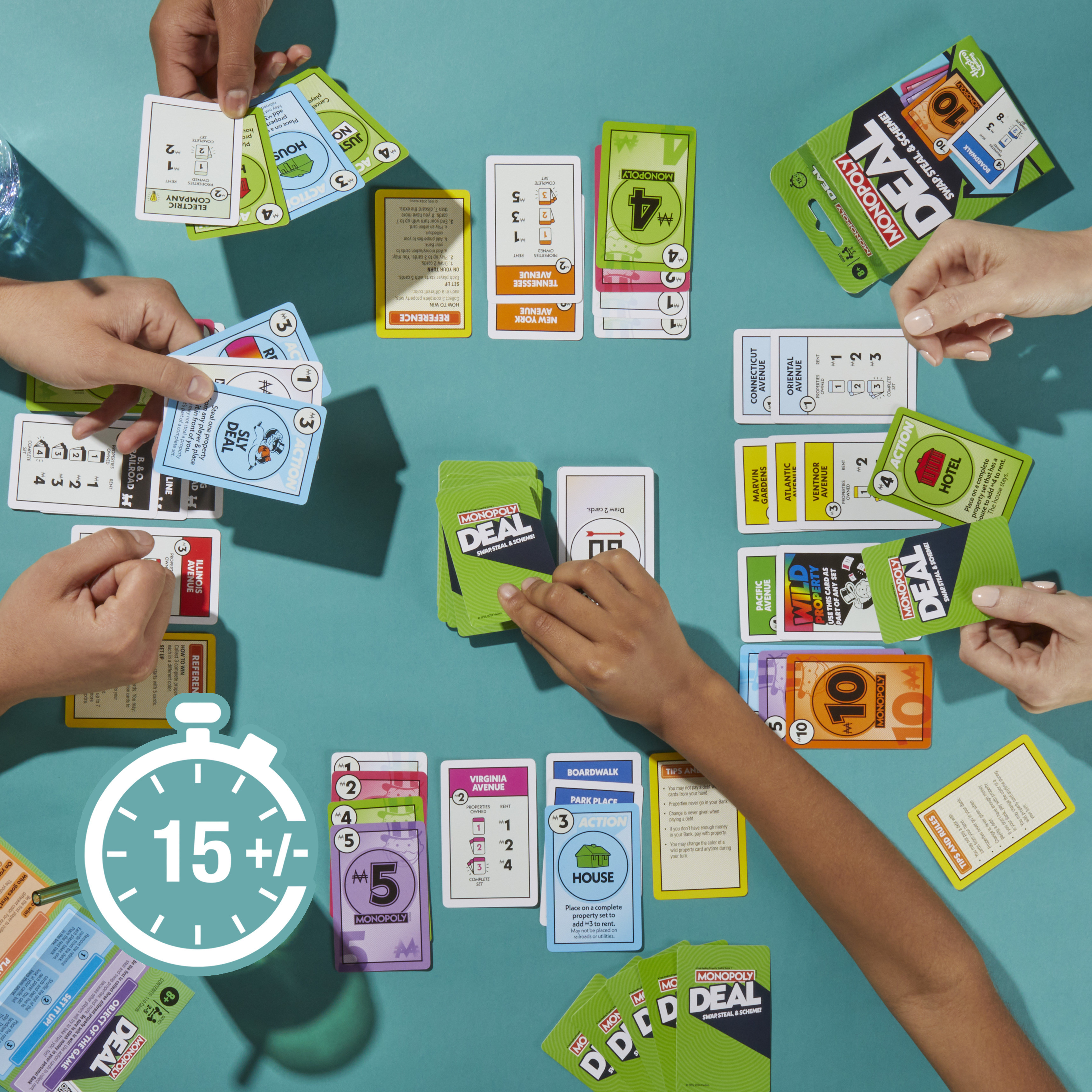 Dłonie grające w grę karcianą Monopoly Deal. Karty z nieruchomościami, akcjami i pieniędzmi na niebieskiej powierzchni.