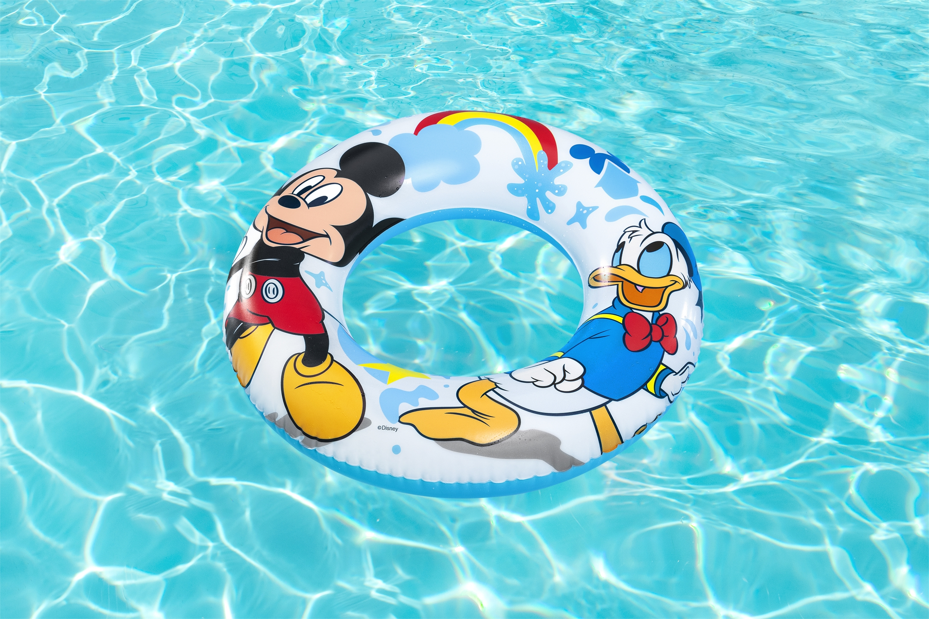 Un flotador inflable de Mickey Mouse y Pato Donald flota en una piscina azul. El agua refleja la luz solar.