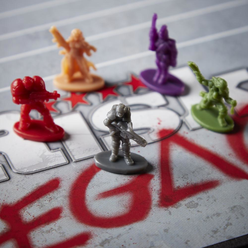 Piezas de juego de mesa de varios colores sobre un tablero con letras rojas estilo grafiti. Las figuras son rojas, moradas, verdes, naranjas y grises.