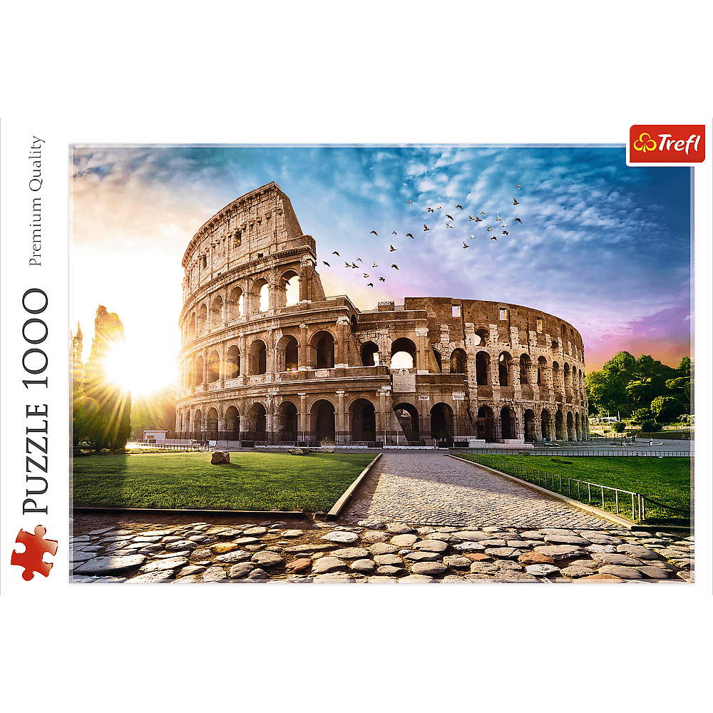 The Colosseum at sunset with birds flying in the sky. Green grass, stone path, and a sunny sky.
