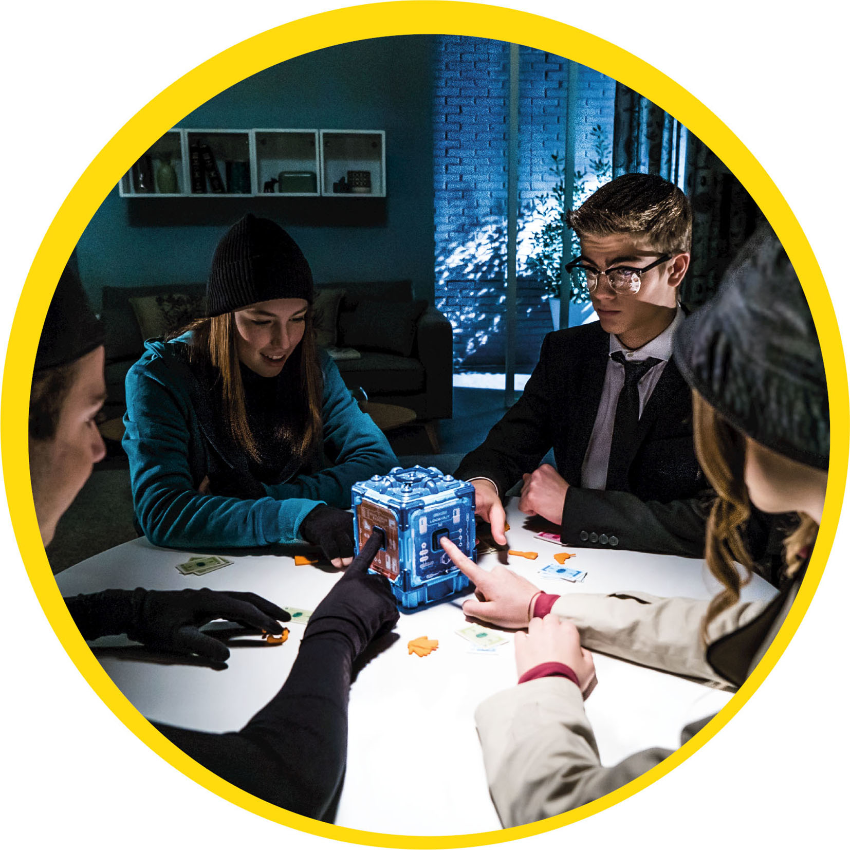 Vier Personen spielen ein Spiel. Sie sitzen um einen Tisch mit einem blauen Würfel. Karten und Spielsteine liegen auf dem Tisch.