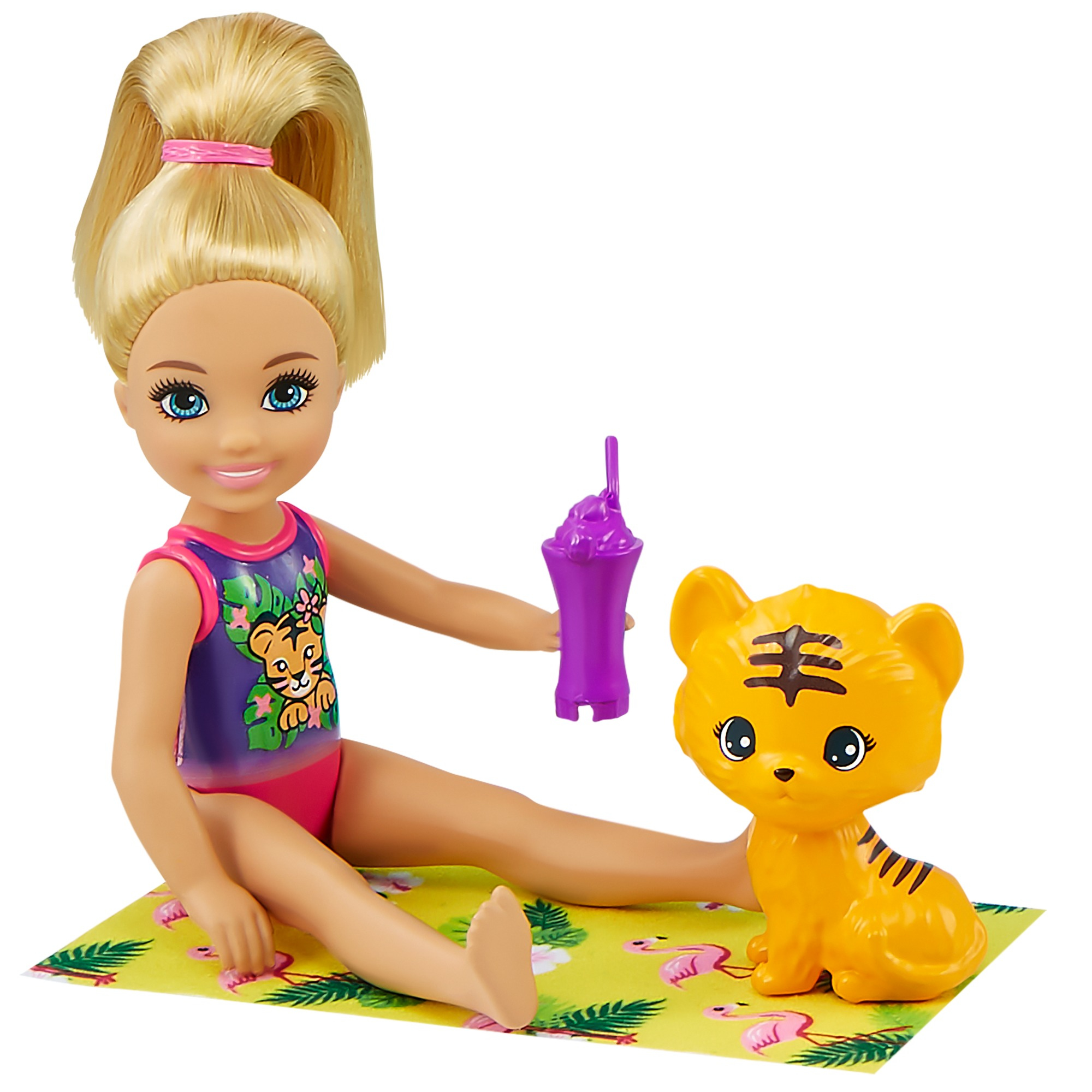Puppe mit blonden Haaren, hält ein lila Getränk, sitzt neben einem Spielzeugtiger auf einer gelben Matte mit rosa Flamingos.