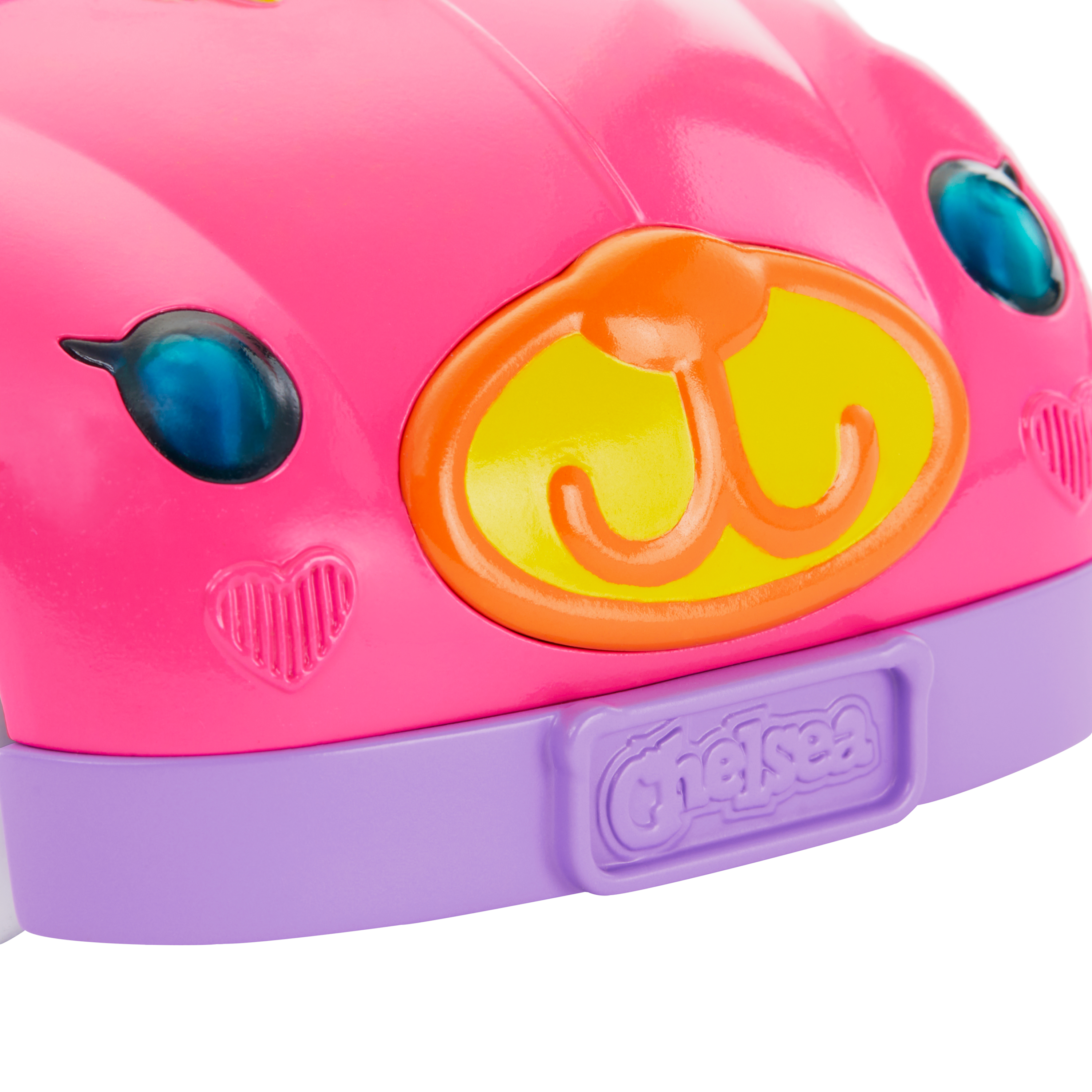Przód różowego autka zabawki z niebieskimi reflektorami, pomarańczowo-żółtym emblematem i fioletową podstawą z napisem "Chelsea".