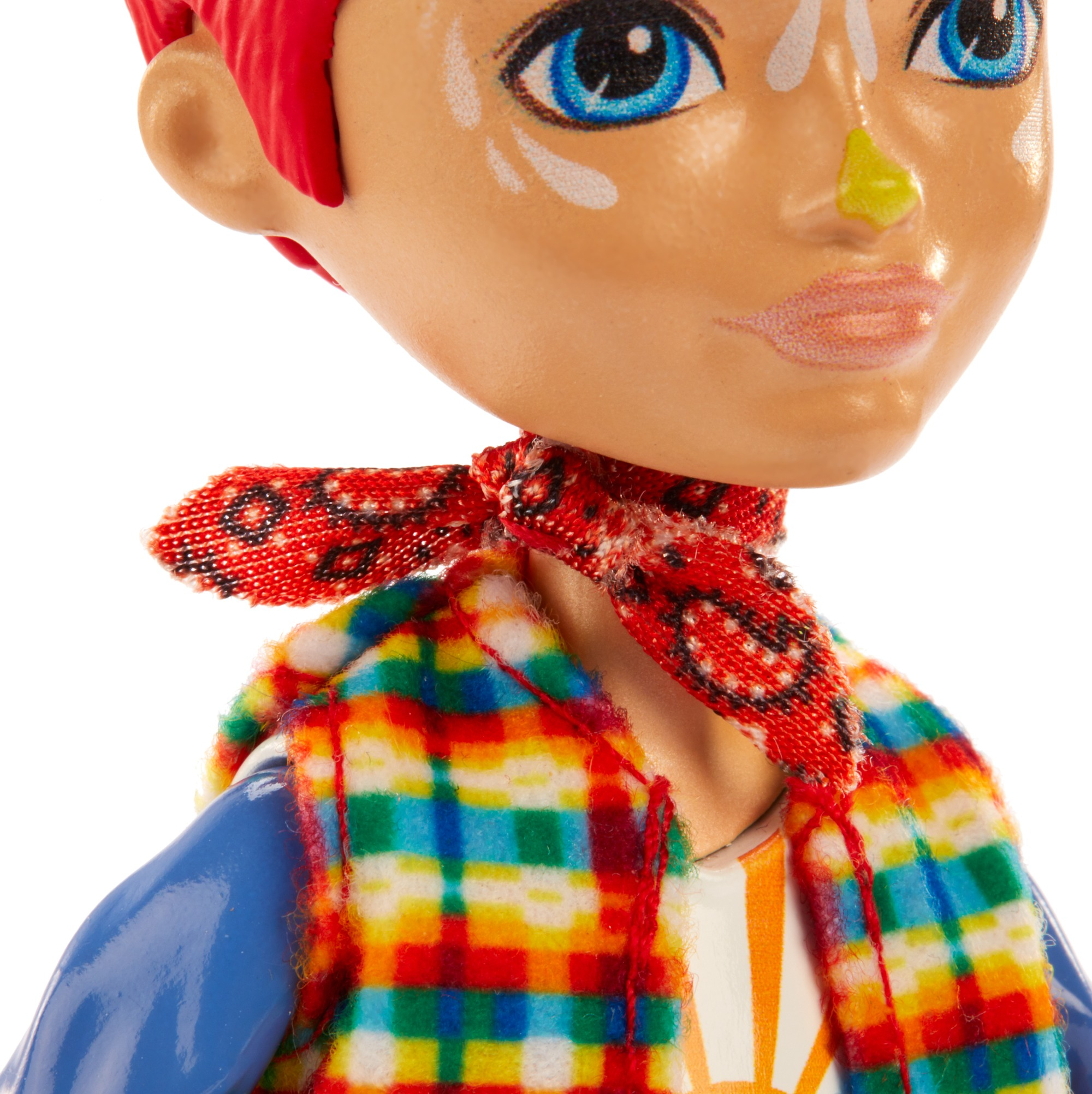 Puppengesicht: rotes Haar, blaue Augen, weiße Farbe, gelbe Nase, roter Schal, bunter Karopullover, blauer Arm. Weißer Hintergrund.