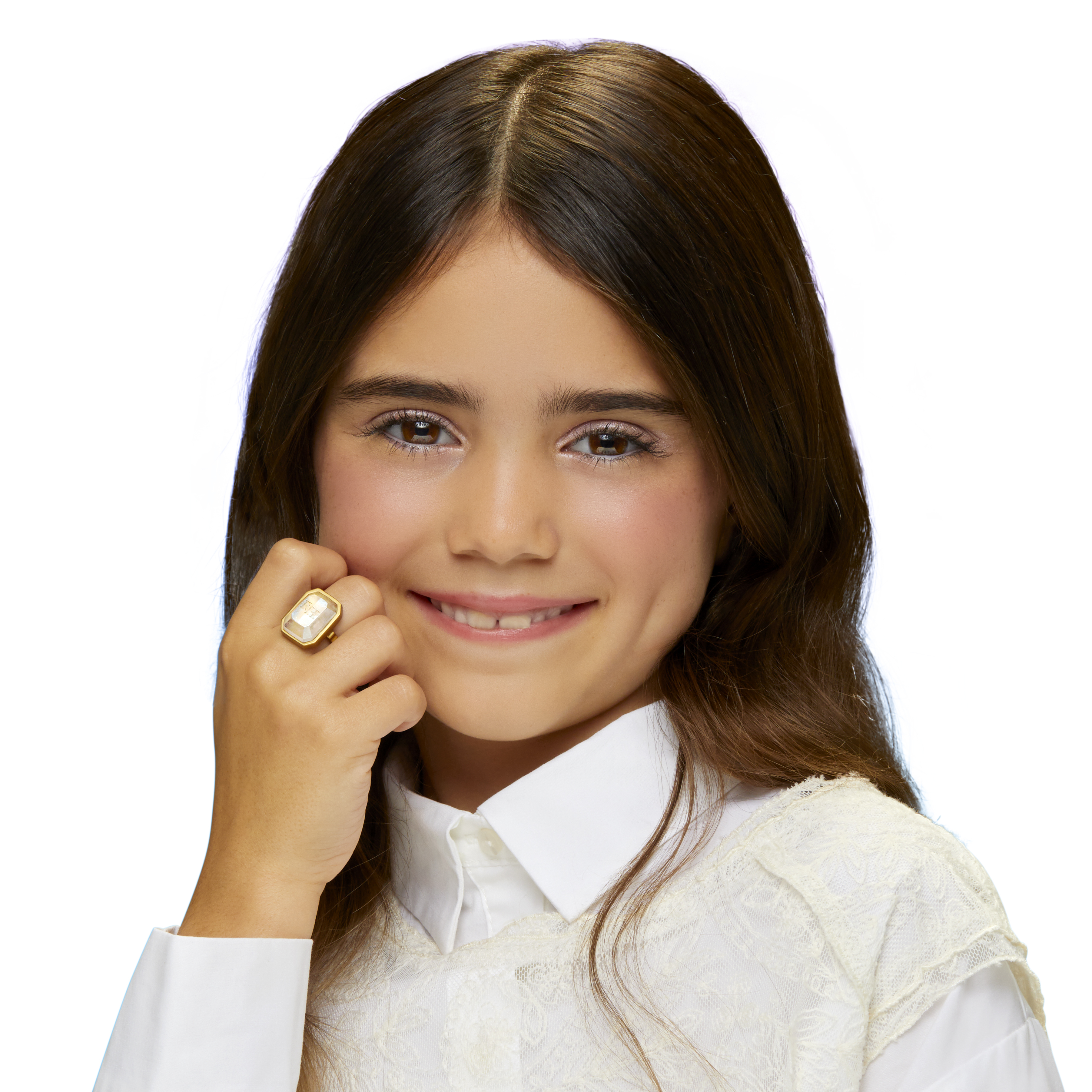 Dziewczyna uśmiecha się, w białej koszuli i z pierścionkiem. Ciemne włosy otaczają jej twarz na białym tle.