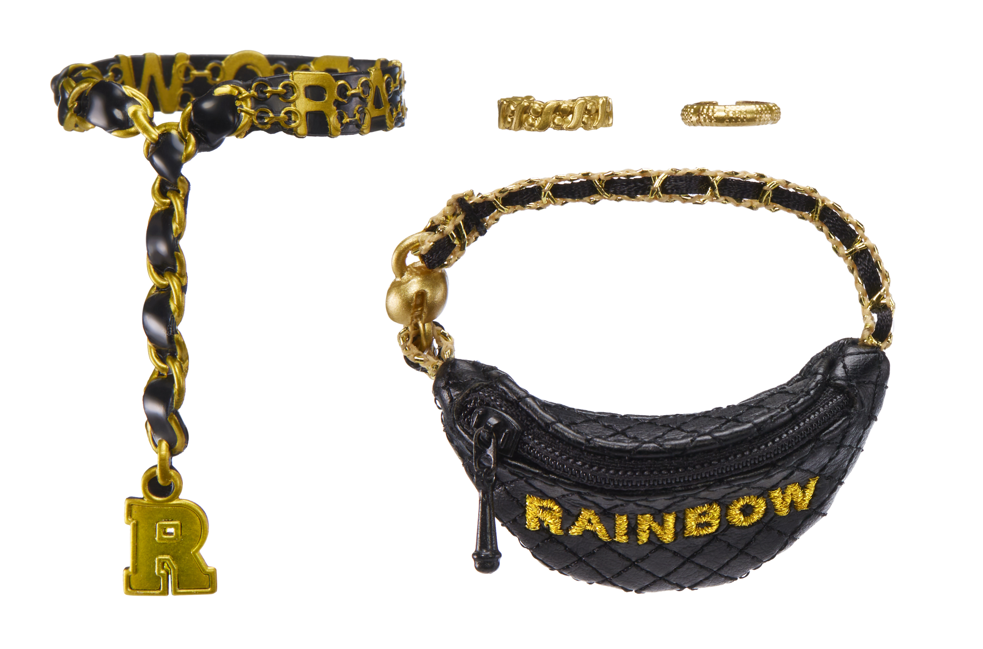 Obraz przedstawia biżuterię: czarno-złoty łańcuszek, dwa pierścionki i czarną nerkę ze złotym napisem 'RAINBOW'.