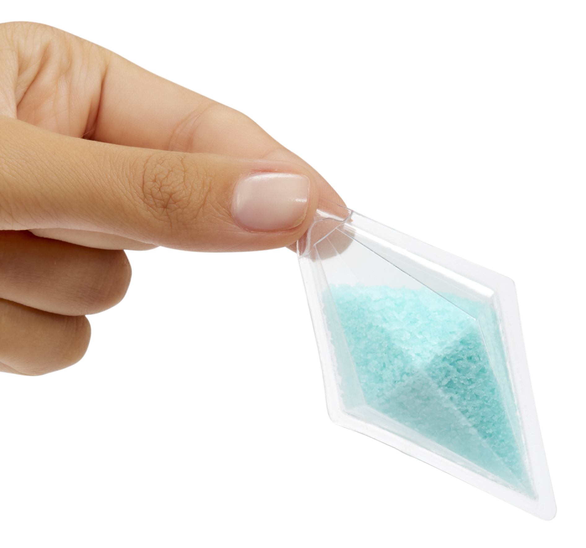 Eine Hand hält eine transparente, rautenförmige Verpackung mit türkisfarbenen Granulaten vor weißem Hintergrund.