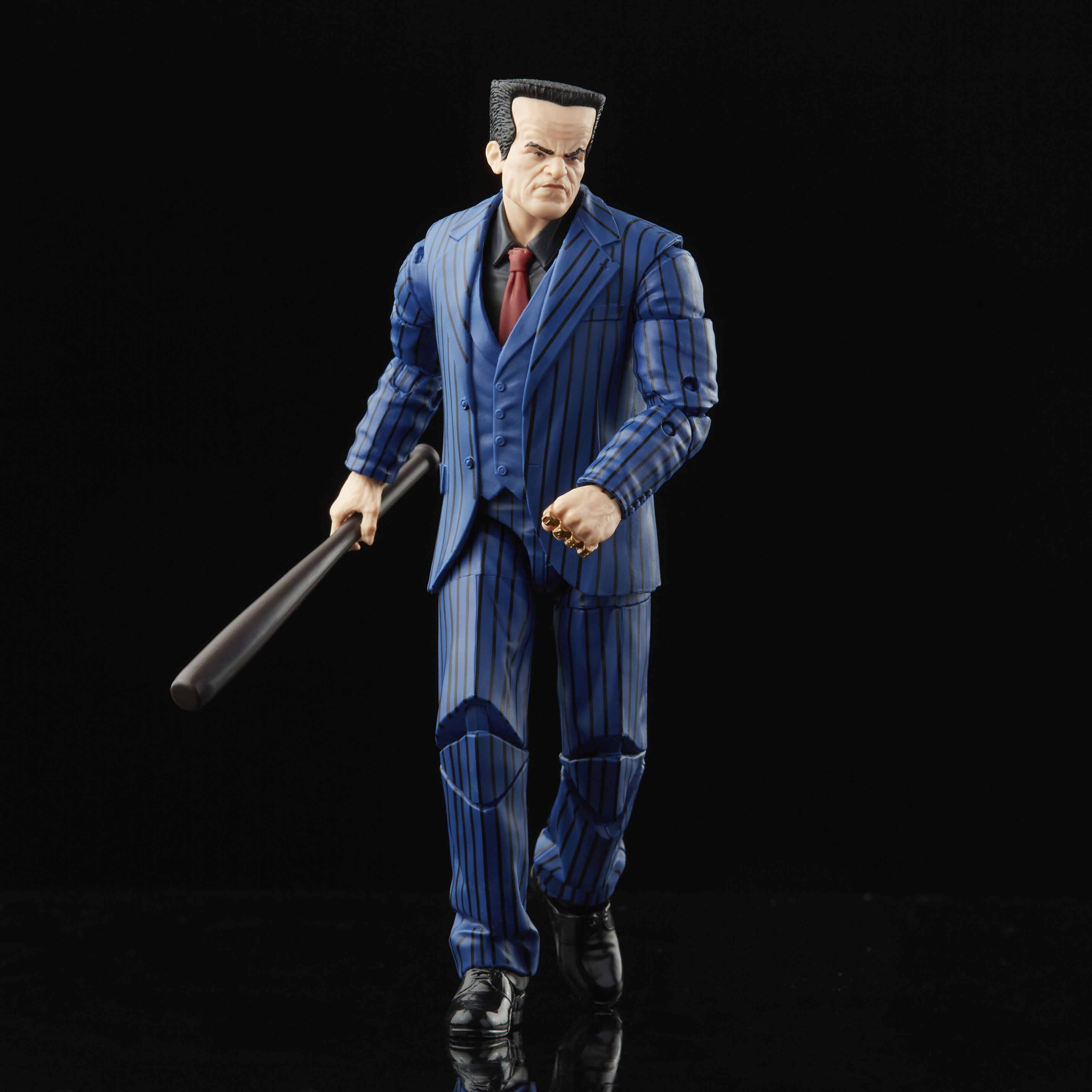 Statuetta di un uomo in abito blu a righe, con una mazza da baseball, su sfondo nero. Ha un'espressione severa.