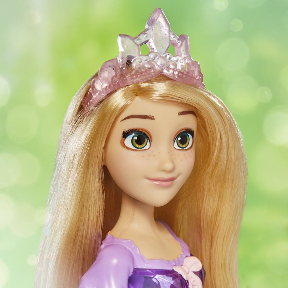Una bambola di Rapunzel con lunghi capelli biondi, una tiara rosa e un vestito viola. Lo sfondo è verde tenue.