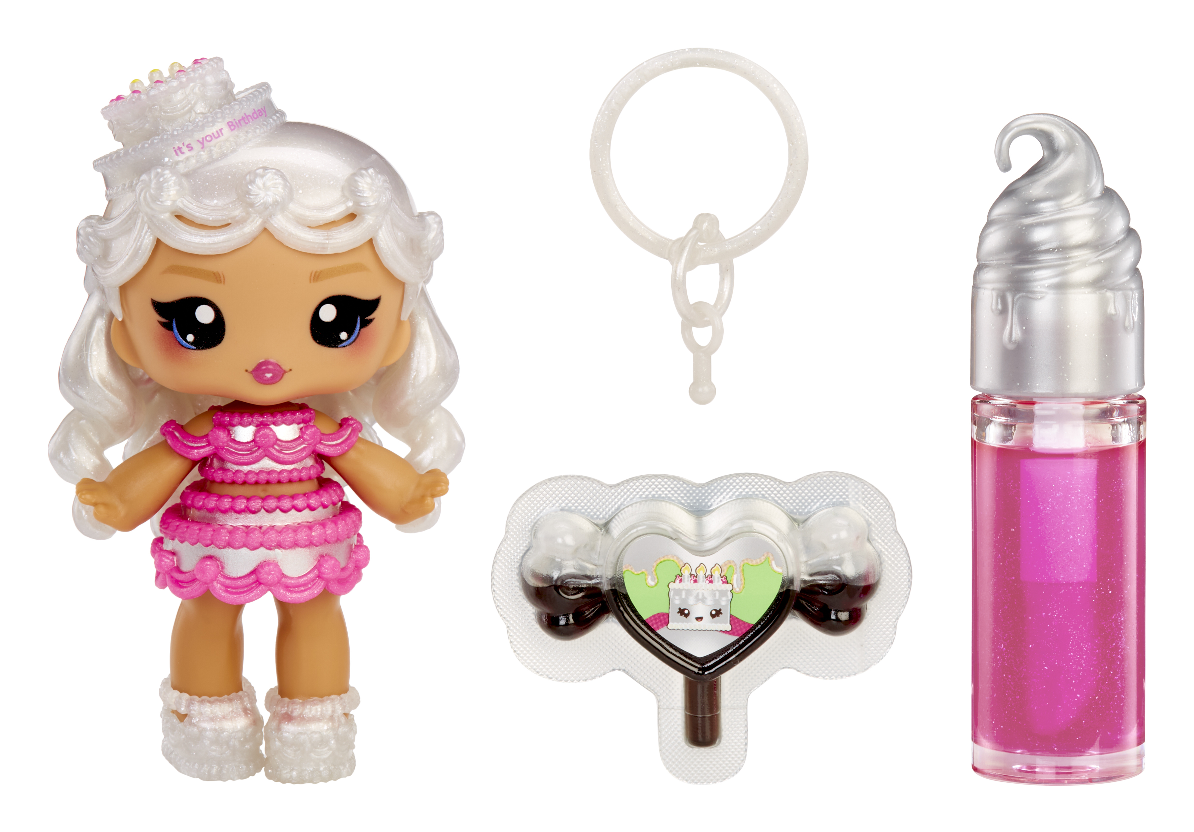 Eine Puppe mit Geburtstagskuchenhut, Lipgloss, einem Schlüsselanhänger und herzförmigen Süßigkeiten auf weißem Grund.