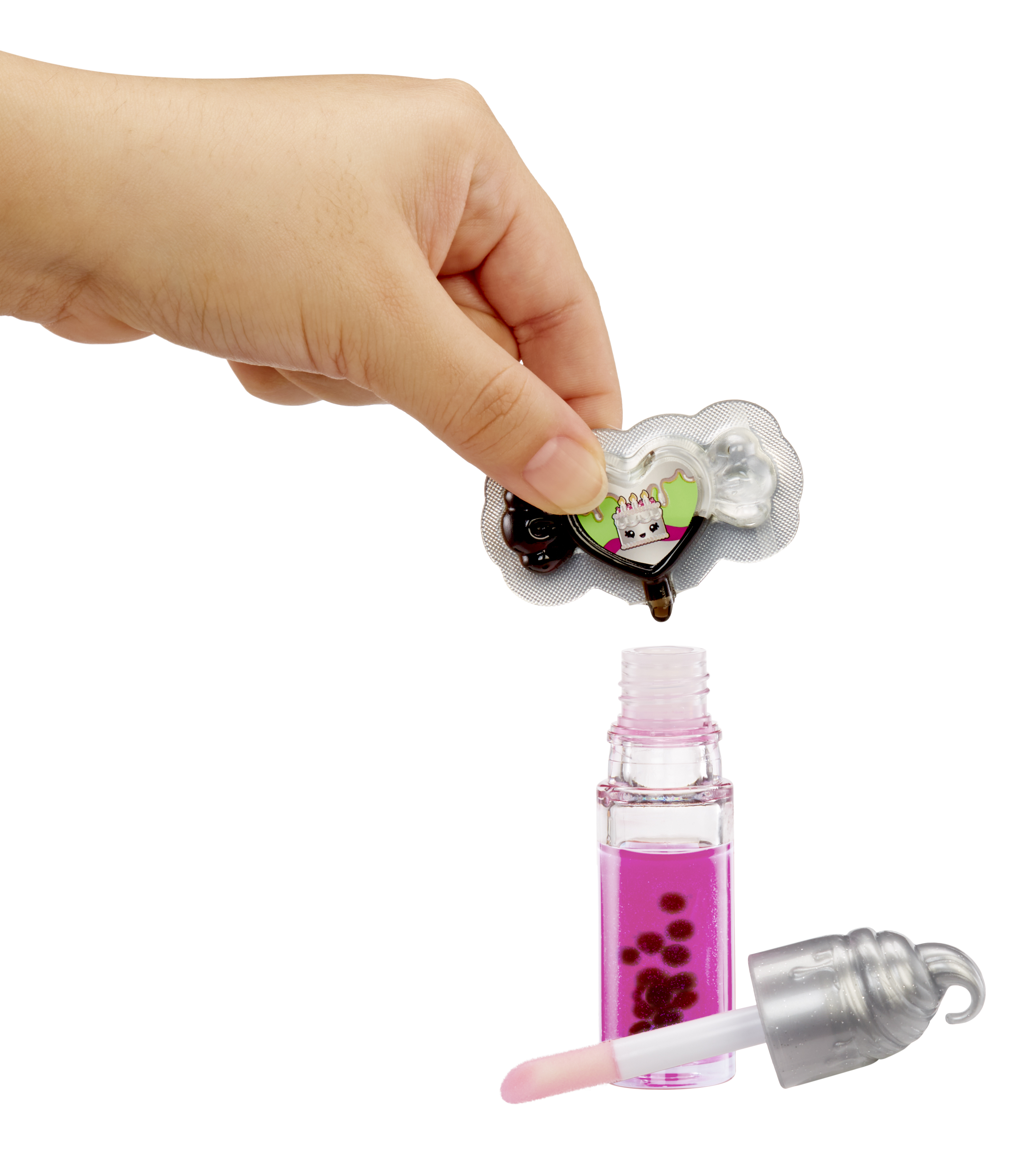Hand hält einen herzförmigen Aufkleber über einem pinkfarbenen Lipgloss. Der Deckel ist ab, der Applikator ist sichtbar.