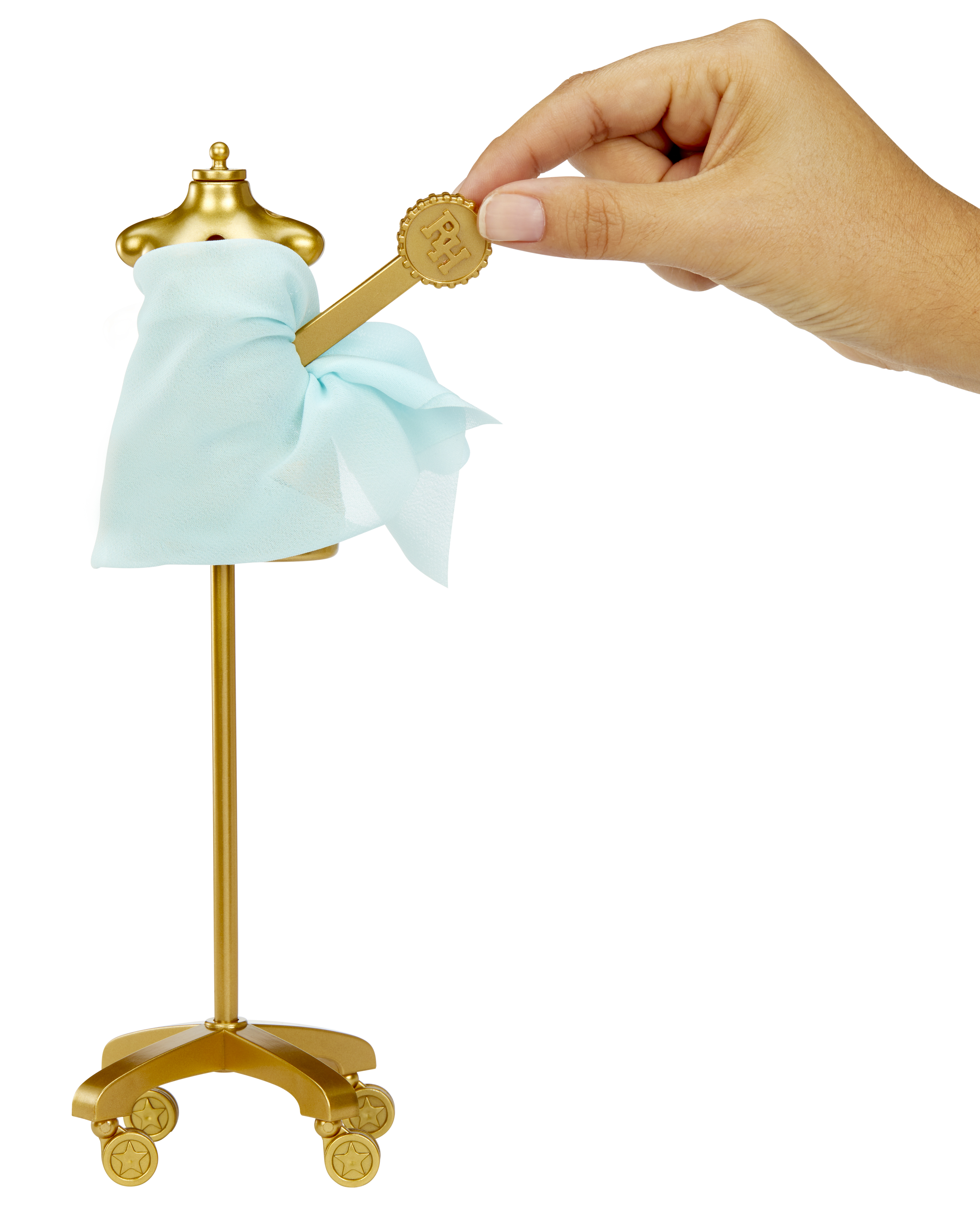 Dłoń trzyma złoty klucz w pobliżu manekina w jasnoniebieskiej tkaninie, wszystko na białym tle.