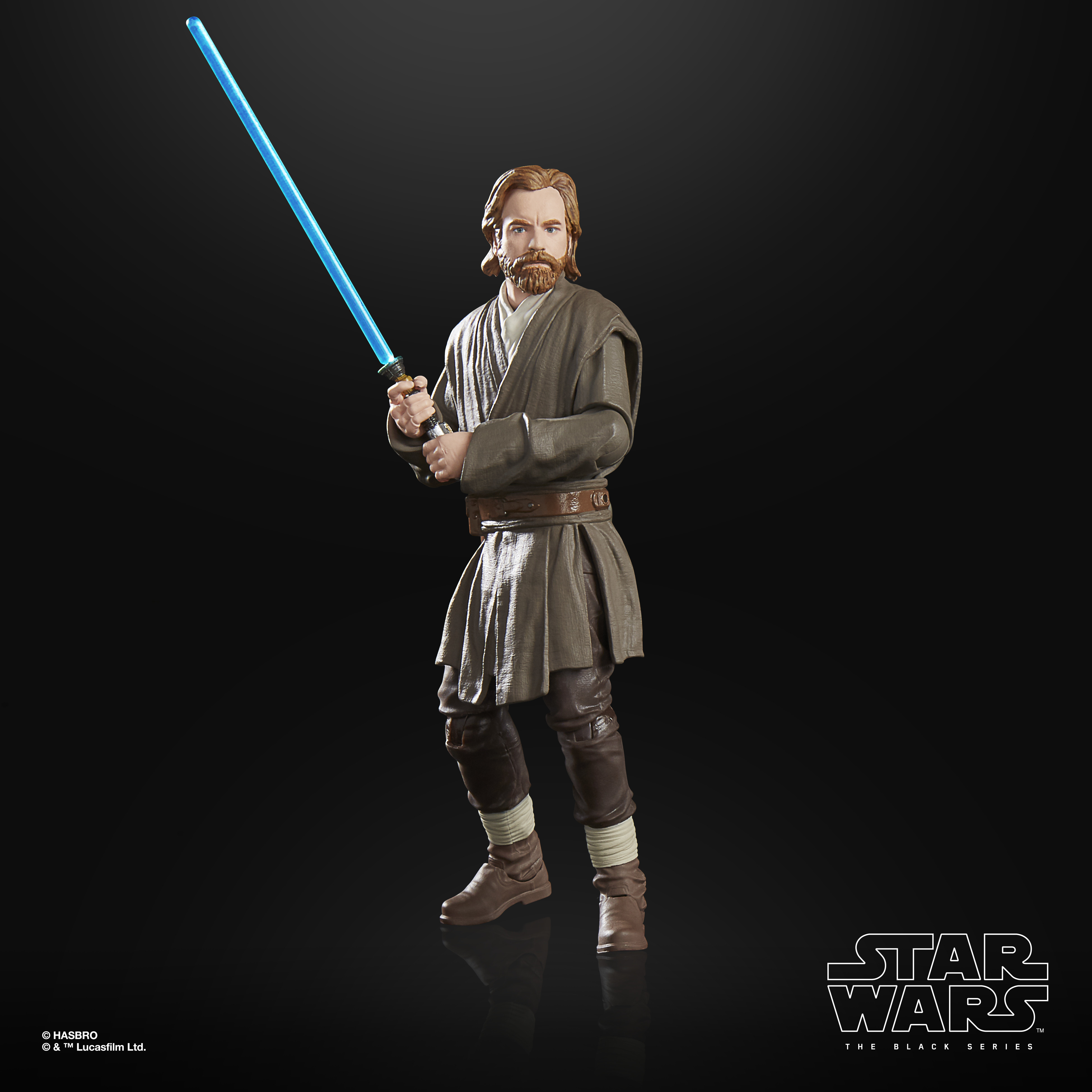 Action figure di Obi-Wan Kenobi con spada laser blu, vesti marroni e stivali, su sfondo nero. Logo Star Wars in basso.