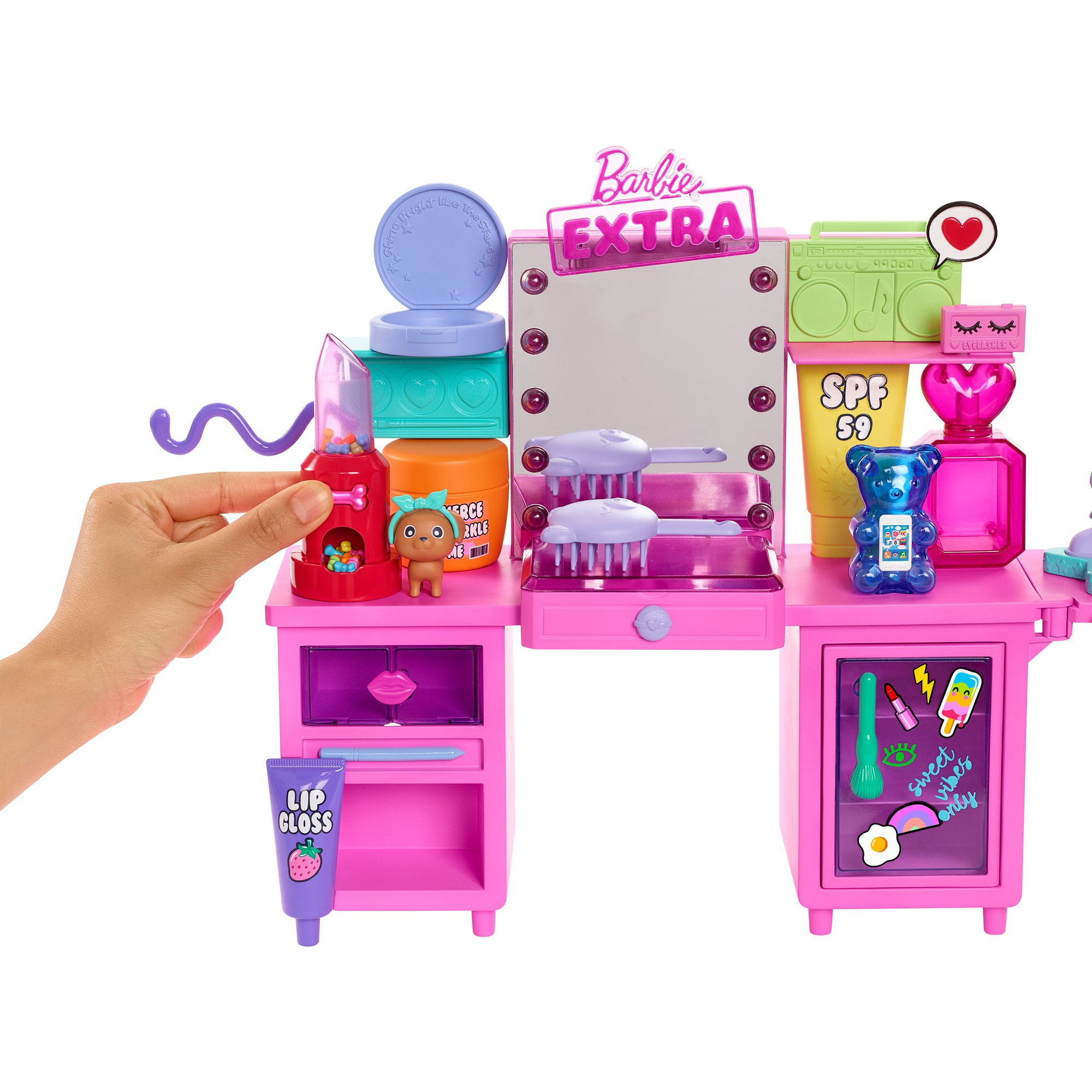 Ein rosa Barbie Extra Schminktisch mit Zubehör. Enthält Spiegel, Schubladen und eine Hand, die nach einem Kaugummiautomaten greift.