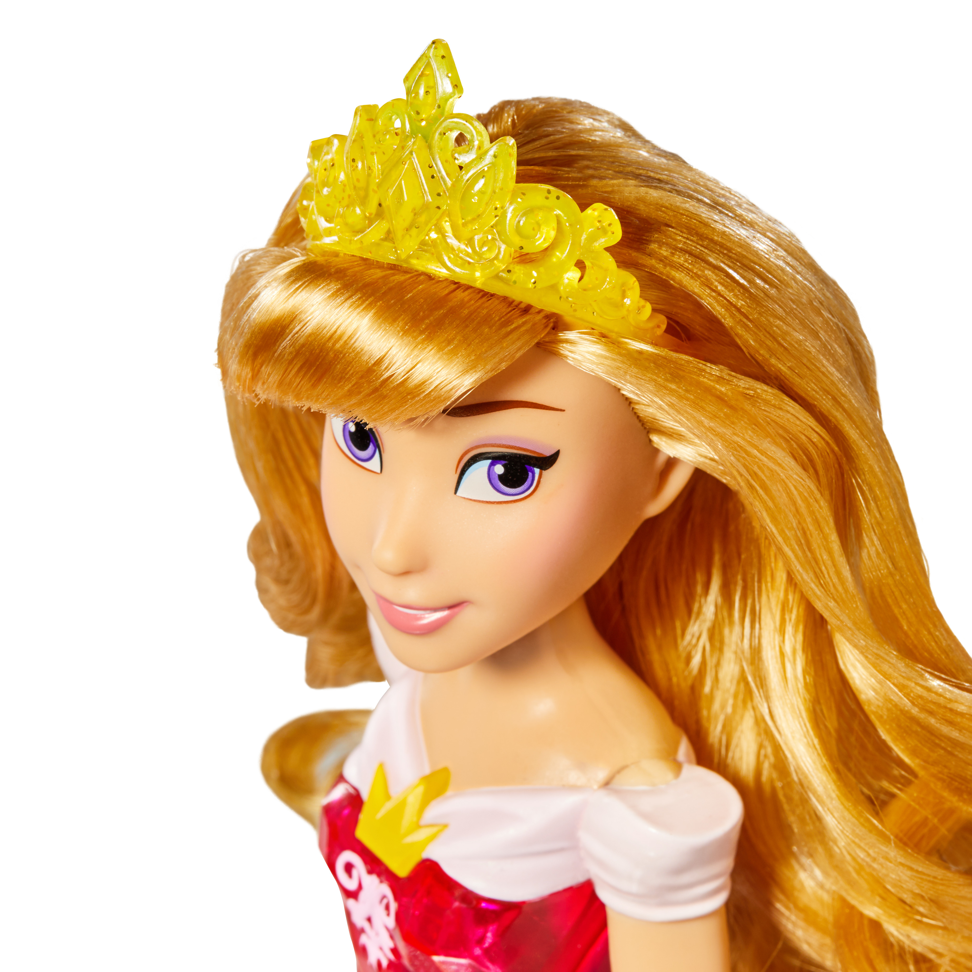 Una bambola di principessa con capelli biondi, una corona gialla e un vestito rosso. Ha occhi viola e un sorriso gentile.