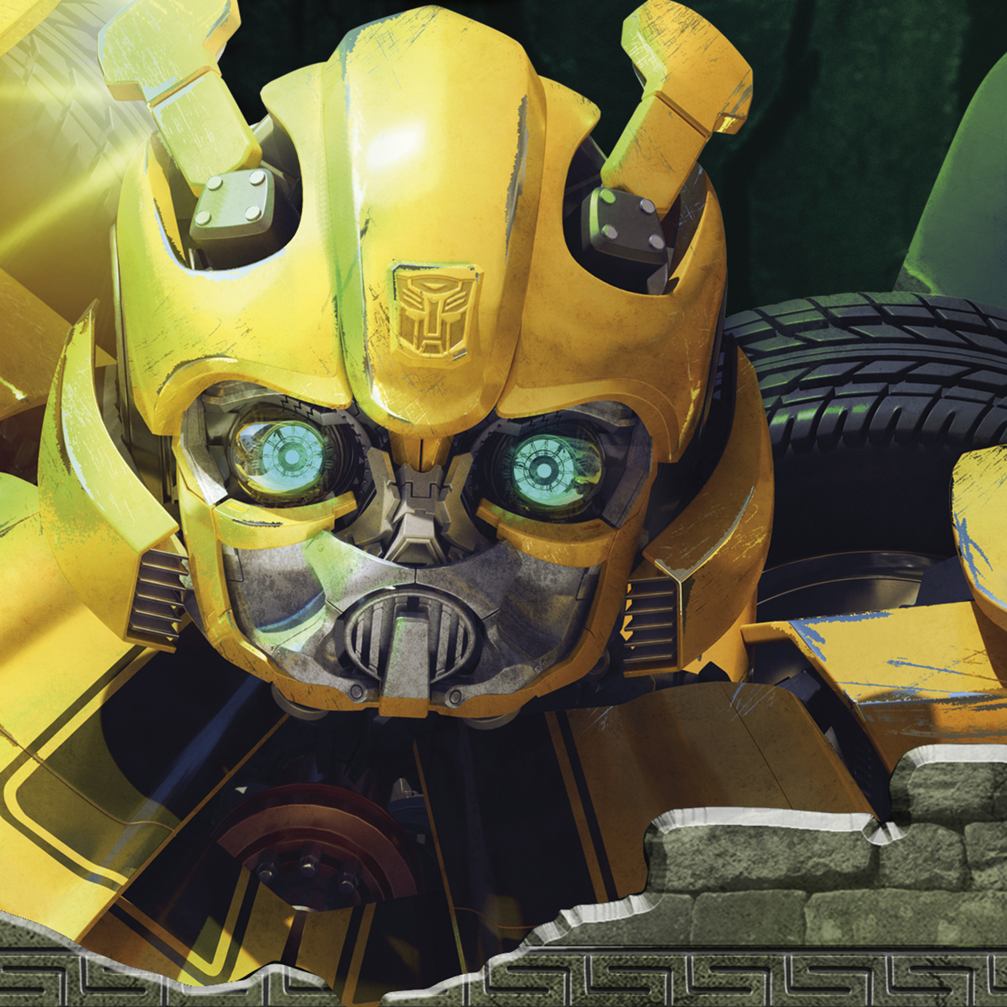 Primer plano de una cara de robot amarilla, posiblemente Bumblebee, con ojos verdes y un neumático visible. Una pared de ladrillos forma el fondo.