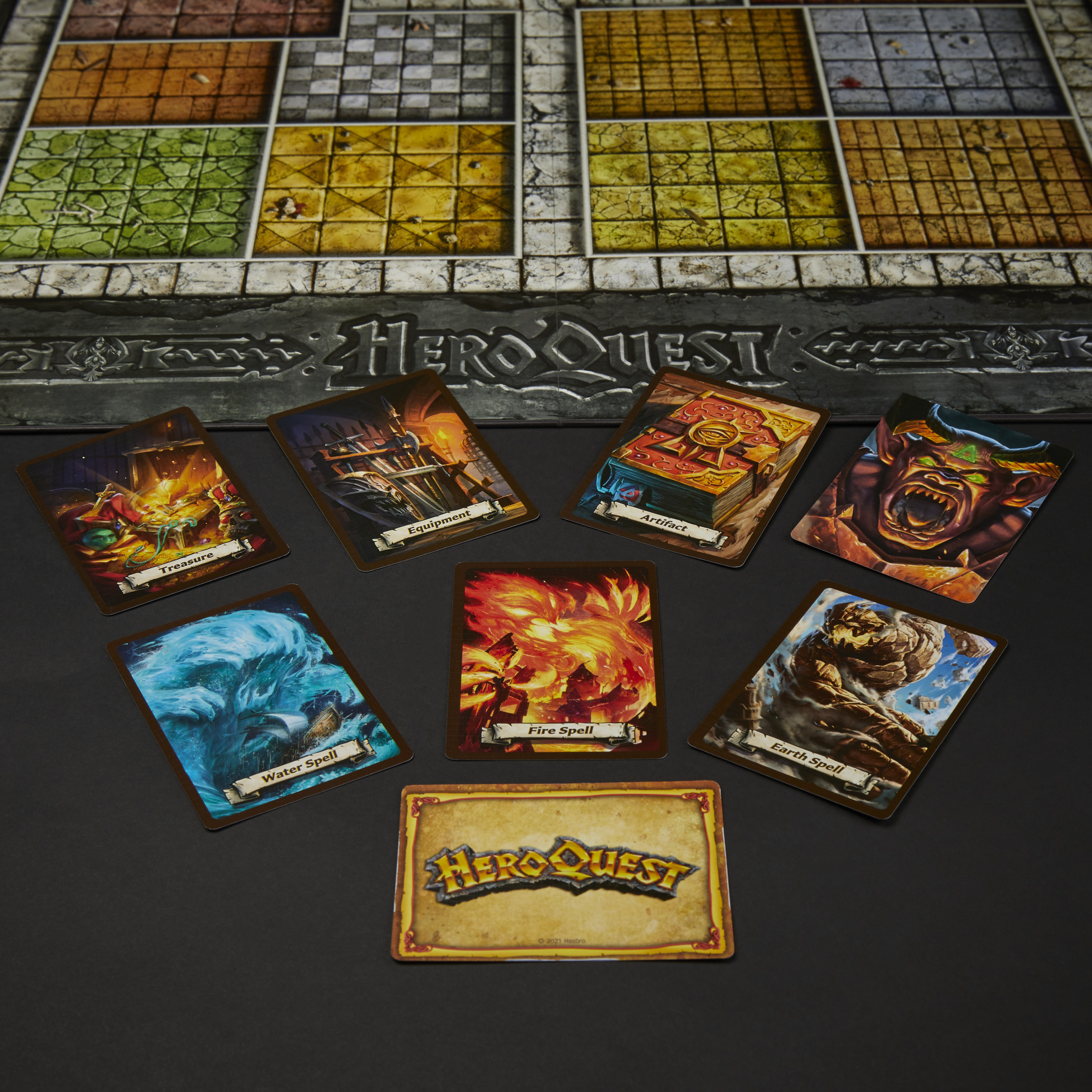 Gioco da tavolo HeroQuest. Carte con incantesimi e tesori su una superficie nera.