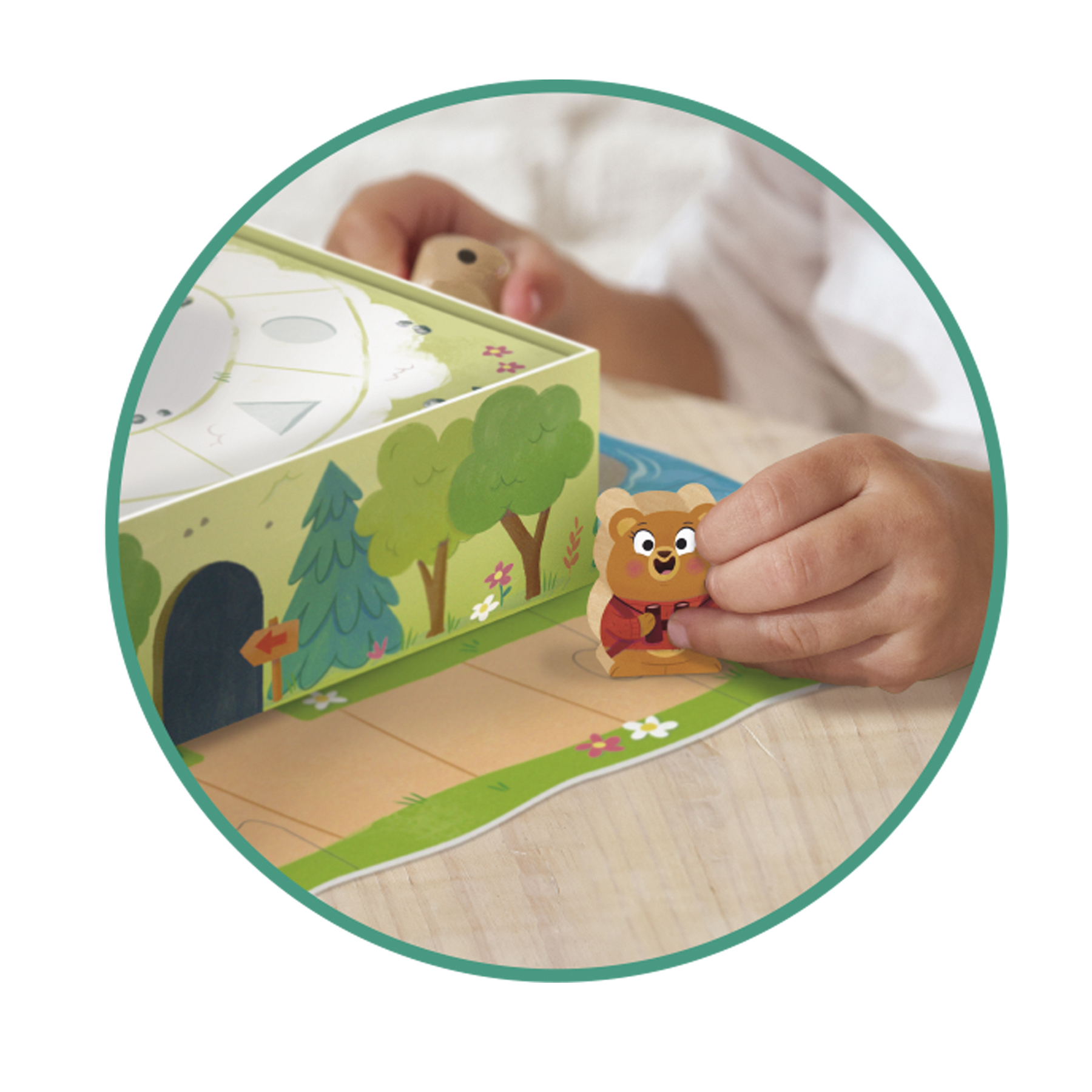 Le mani di un bambino che gioca a un gioco da tavolo con una figurina di orso. Il gioco presenta una scena della foresta e un dado.