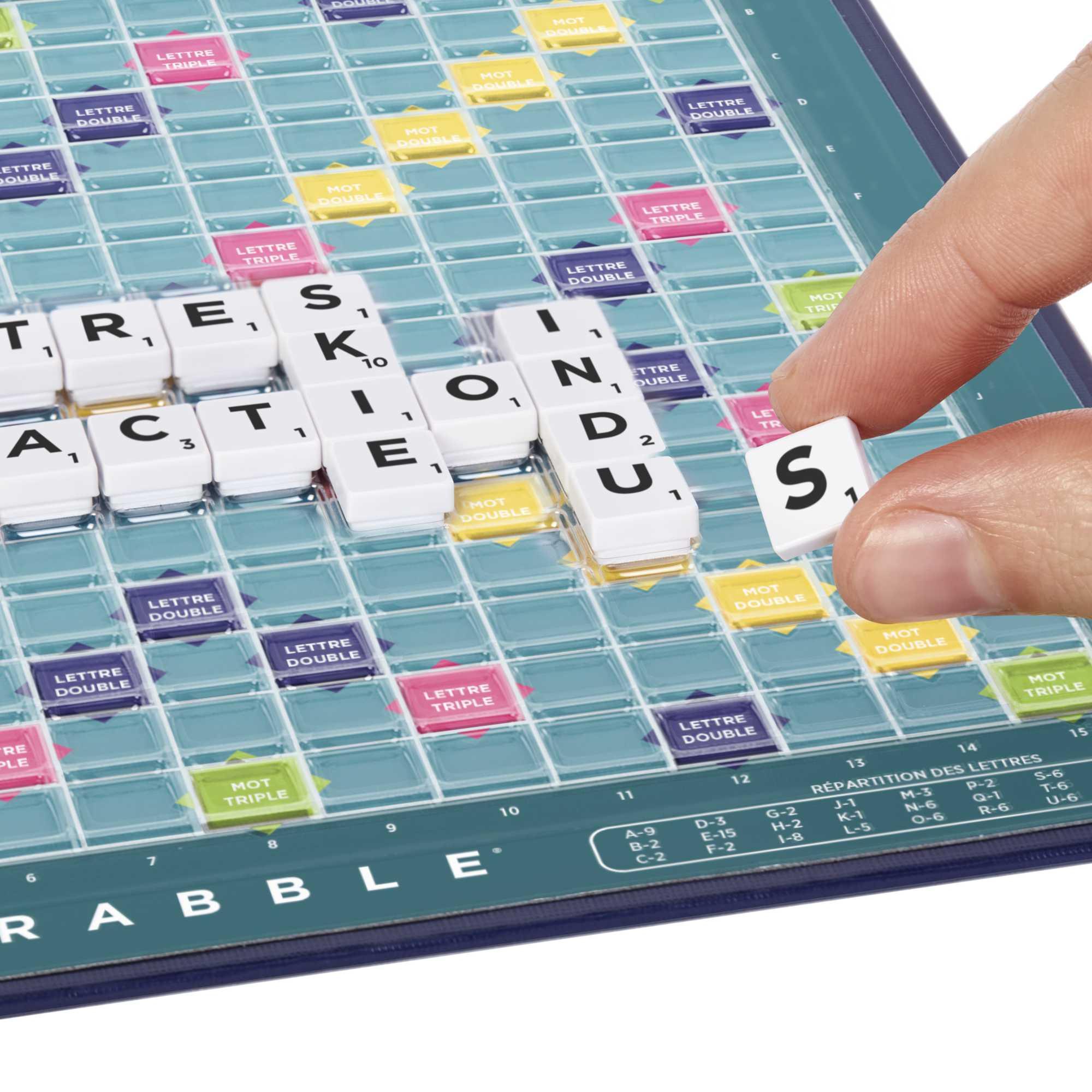 Een hand plaatst een Scrabble-tegel op het bord. Het bord heeft letters en bonusvakken. De tegels spellen ACTION.