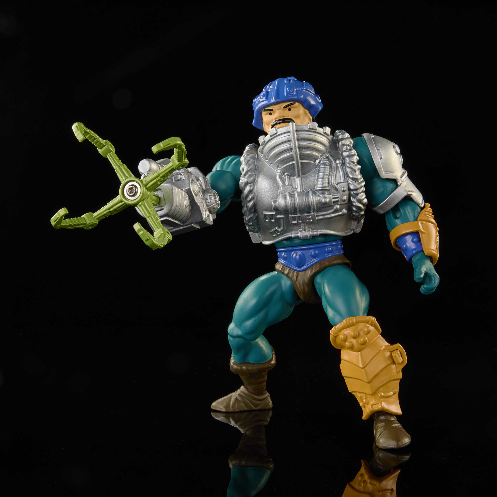 Figura de acción de un hombre con armadura. Tiene un casco azul, una pechera plateada y un arma de garra verde.